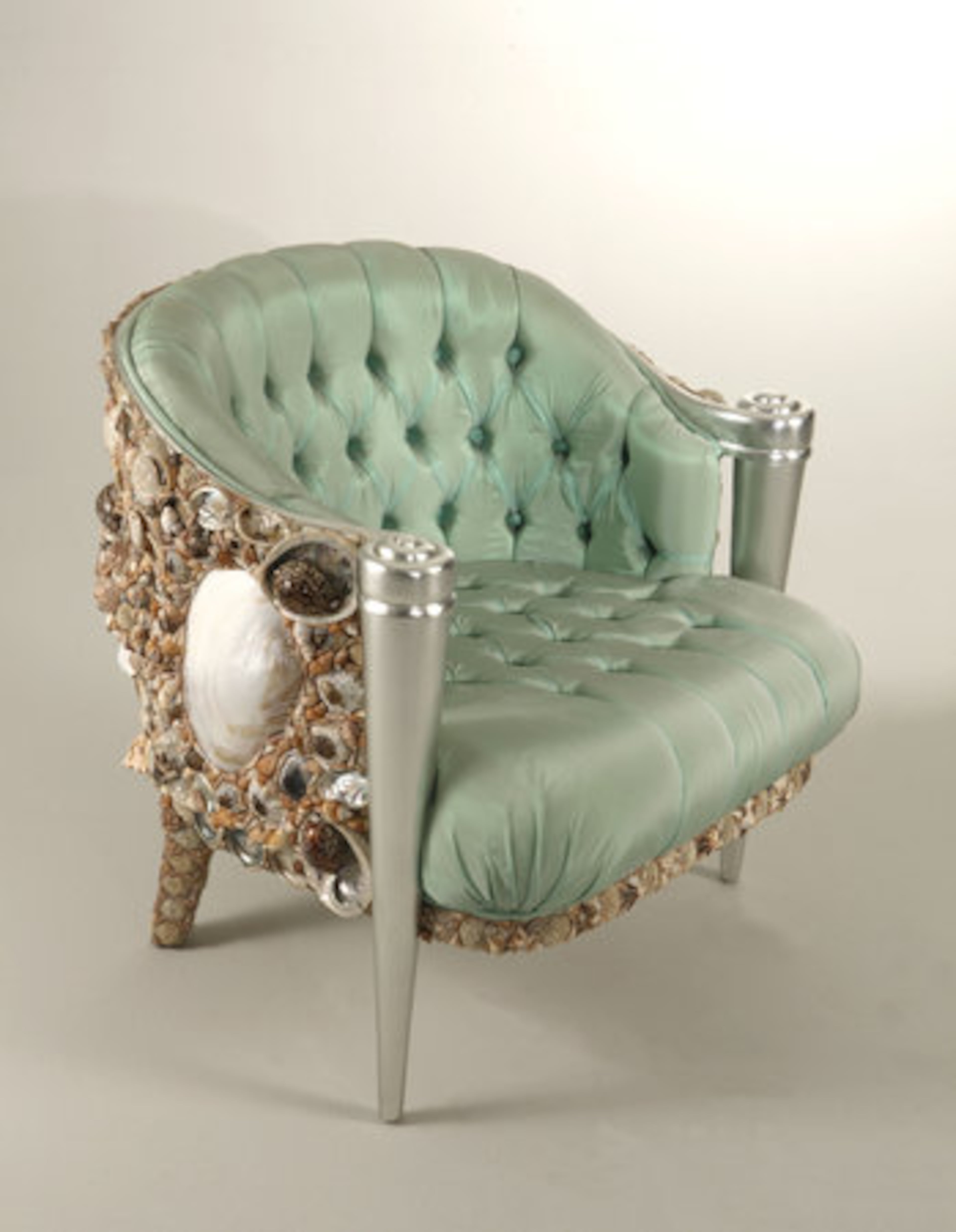 The "Haute Couture" shells chair is a whimsical bergere upholstered in button tufted sea foam green silk and encrusted in seashells, with silver leaf front legs. It was designed by Carlo Rampazzi and handmade in Italy. It retails for more than $27,000.