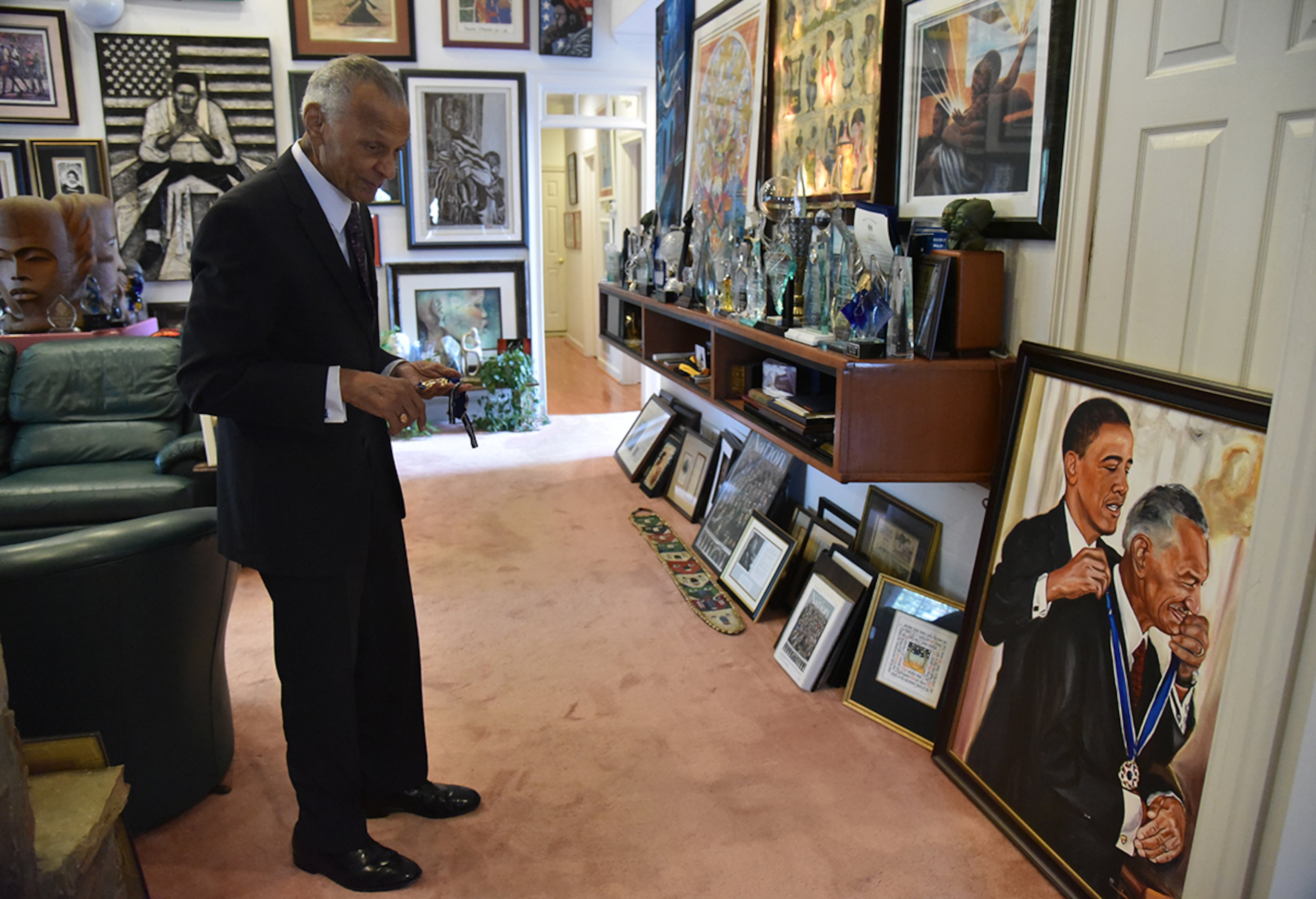 July 25, 2017 Atlanta - C.T. Vivian looks at a painting of himself with President Barack Obama as he holds his Presidential Medal of Freedom on Tuesday, July 25, 2017. The National Monuments Foundation will be acquiring and managing the world-class library of Atlanta Civil Rights icon, C.T. Vivian. The library will be housed in the new Cook Park in Vine City. Vivian lived in the same Vine City neighborhood that will border Cook Park where his library is to be constructed under a 101-foot Peace Column. The 6,000 volume C.T. Vivian Library is one of the most impressive private collections in the city. HYOSUB SHIN / HSHIN@AJC.COM