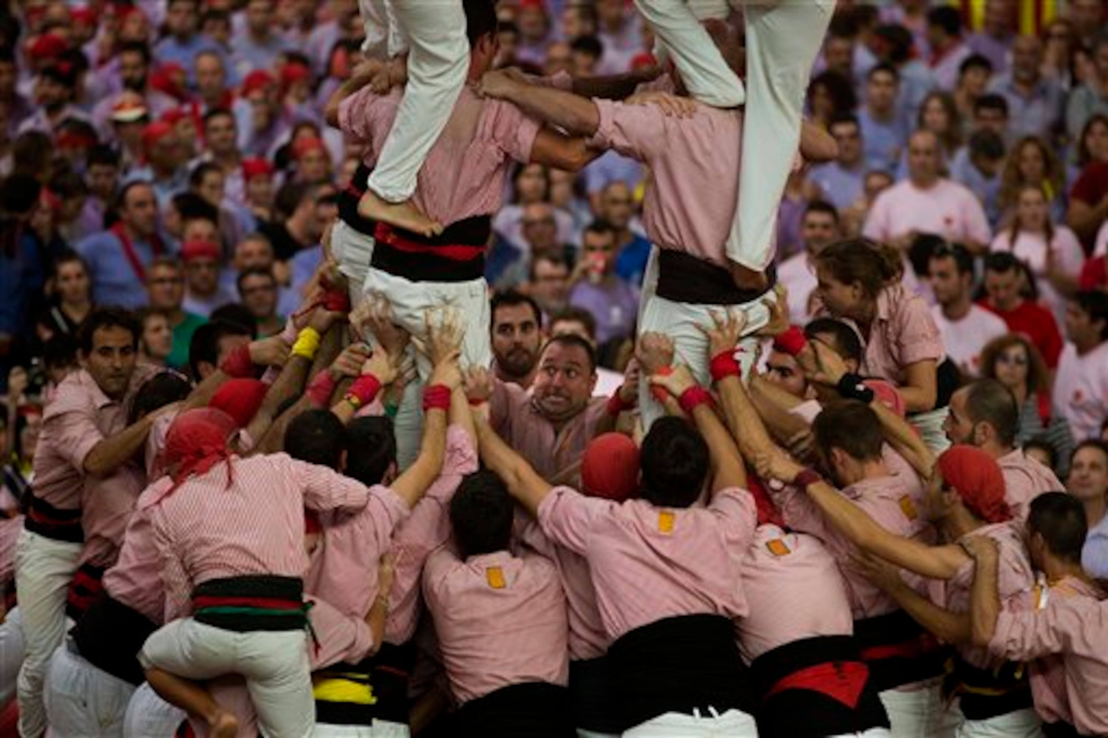 Members of the Castellers de Tarragona work together making their human tower during the 25th Human Tower Competition in Tarragona, Spain, on Sunday, Oct. 5, 2014. The tradition of building human towers or �castells� dates back to the 18th century and takes place during festivals in Catalonia, where �colles� or teams compete to build the tallest and most complicated towers. The structure of the �castells� varies depending on their complexity. A �castell� is considered completely successful when it is loaded and unloaded without falling apart. The highest �castell� in history was a 10 floor structure with 3 people in each floor. In 2010 �castells� were declared by UNESCO one of the Masterpieces of the Oral and Intangible Heritage of Humanity. (AP Photo/Emilio Morenatti)