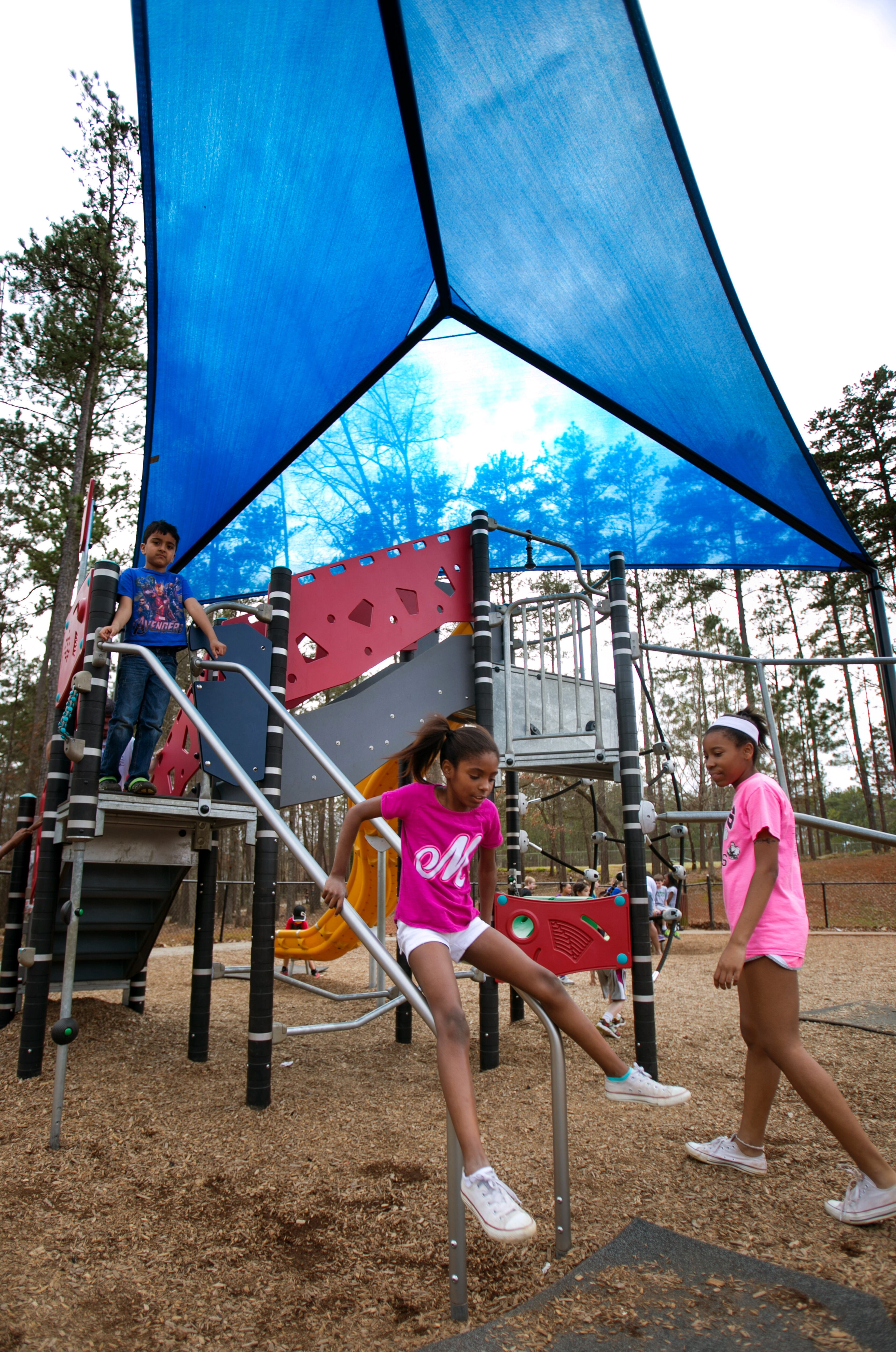 March 21, 2015 - Johns Creek, Ga: Paige Davis, 8, left, and her sister Kennedy Davis, 13, both of Alpharetta, play at playground at Newtown Park Saturday, March 21, 2015, in Johns Creek, Ga.. The girls were their with their aunt Sonya White, of Alpharetta. This is for a story on the Newtown community. PHOTO / JASON GETZ