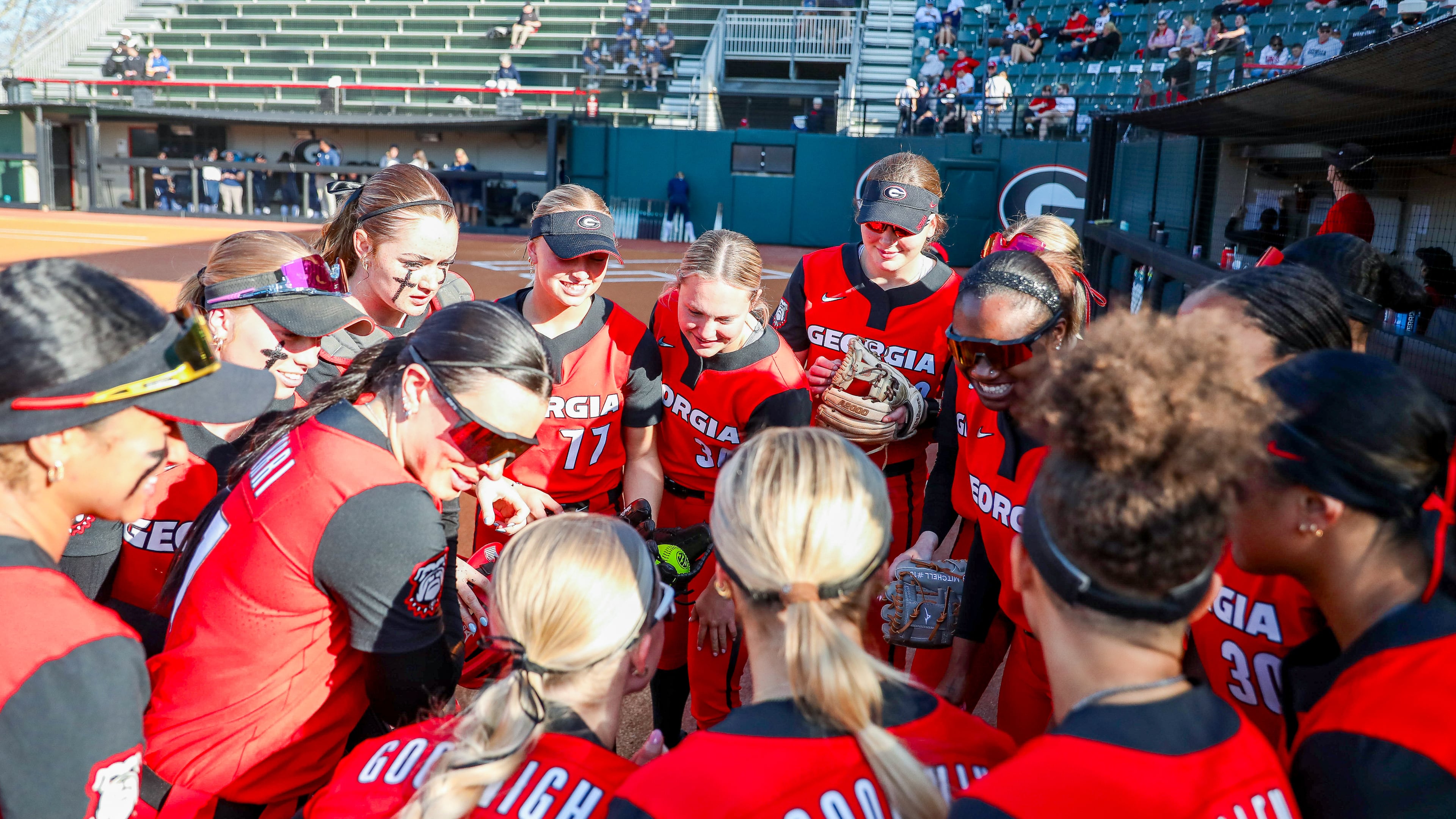 Georgia pitcher Ella Troutt (77), catcher Marisa Miller (56) and other players huddle before Georgia’s game against Georgia Southern at Jack Turner Stadium in Athens, Mar. 12, 2025. (Gabriel Cox/UGAAA)