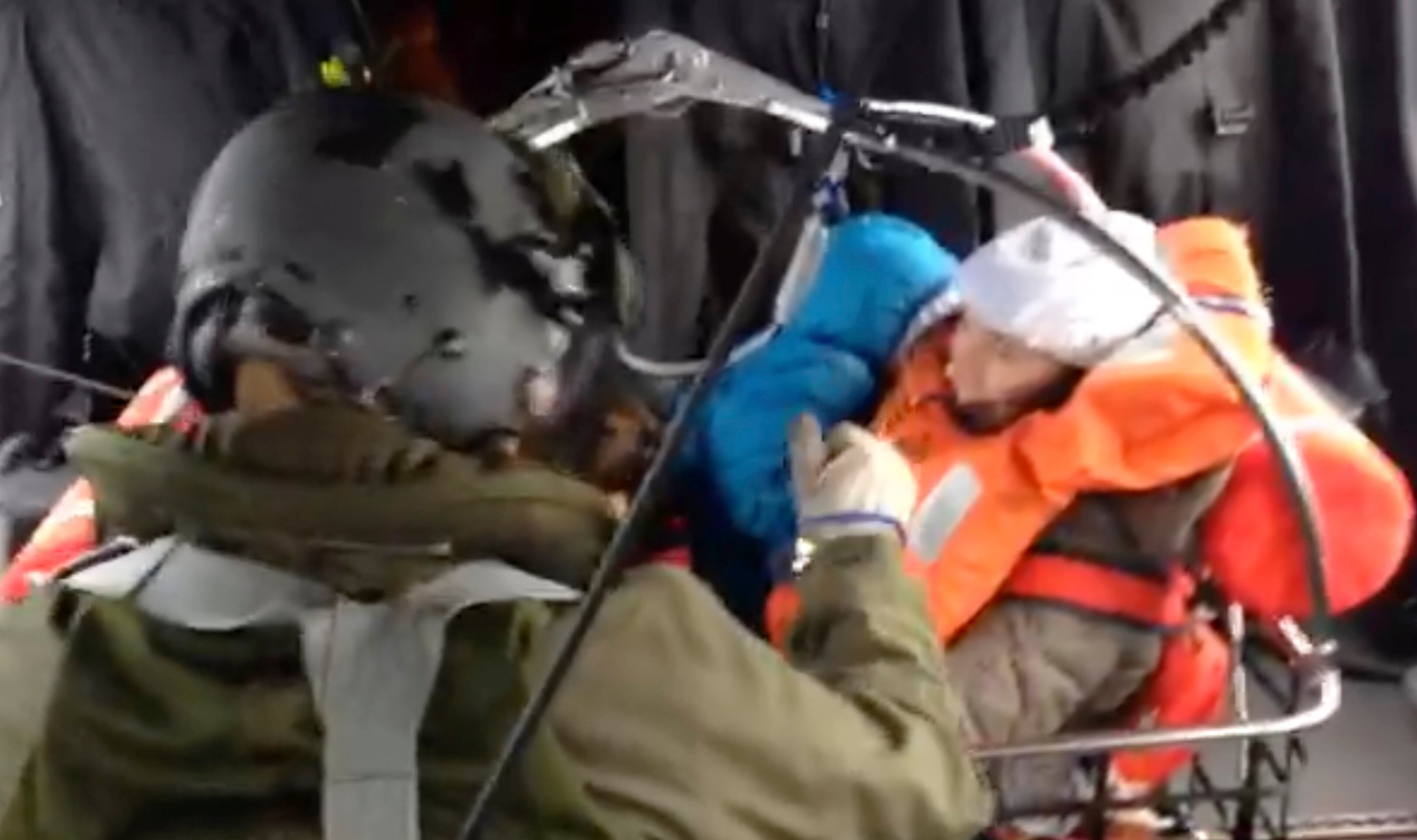 In this image taken from a video released by the Italian Air Force, a woman holds her baby as they sit in a wire basket being hosted aboard an Italian Air Force helicopter after the Italian-flagged Norman Atlantic caught fire in the Adriatic Sea, Sunday, Dec. 28, 2014. Italian and Greek rescue crews battled gale-force winds and massive waves as they struggled Sunday to evacuate hundreds of people from a ferry on fire and adrift in the channel between Italy and Albania. (AP Photo/Italian Air Force)