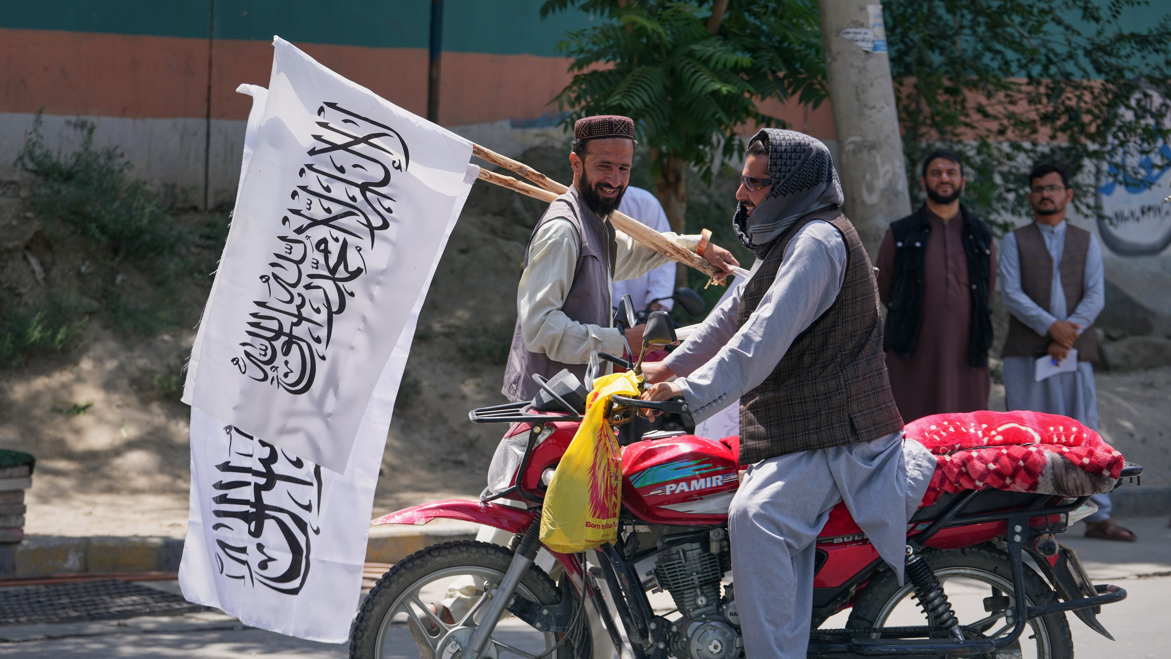 A man offers Taliban flags for sale ahead of celebrations marking the fifth anniversary of the U.S. withdrawal from Afghanistan and the start of Taliban rule, in Kabul, Afghanistan, Thursday, Aug. 13, 2026. (AP Photo/Siddiqullah Alizai)