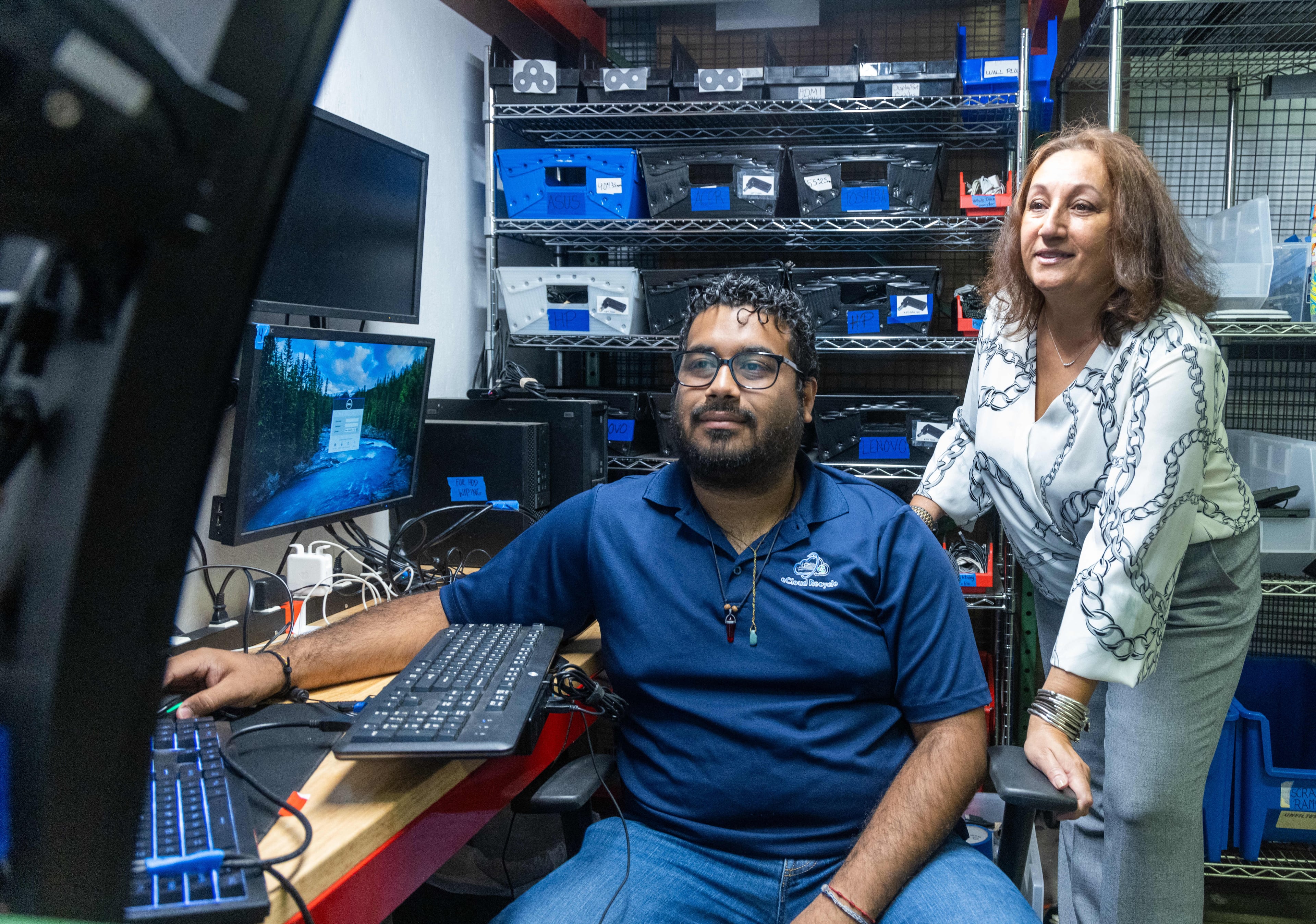Diego Irias (left), works on refurbishing a laptop at eCloud Recycle while Yvonne David watches. PHIL SKINNER FOR THE ATLANTA JOURNAL-CONSTITUTION
