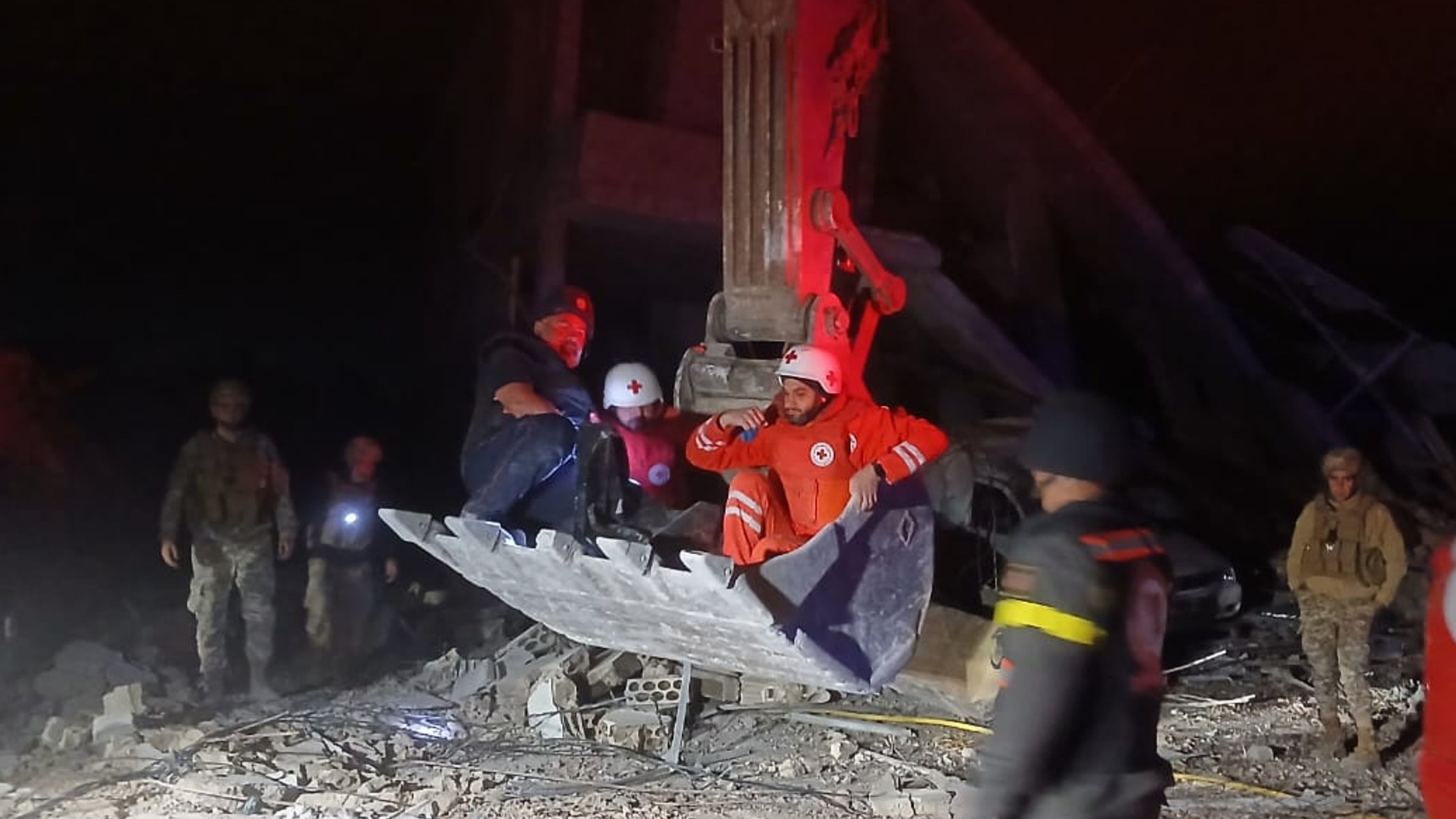 This photo released by the Lebanese Civil Defense, show Lebanese Red Cross volunteers and a Civil Defense worker sit on a excavator carrying the body of the Lebanese journalist Amal Khalil working for the daily Al-Akhbar newspaper killed in an Israeli airstrike, in al-Tiri village, south Lebanon, Wednesday, April 22, 2026. (Lebanese Civil Defense via AP)