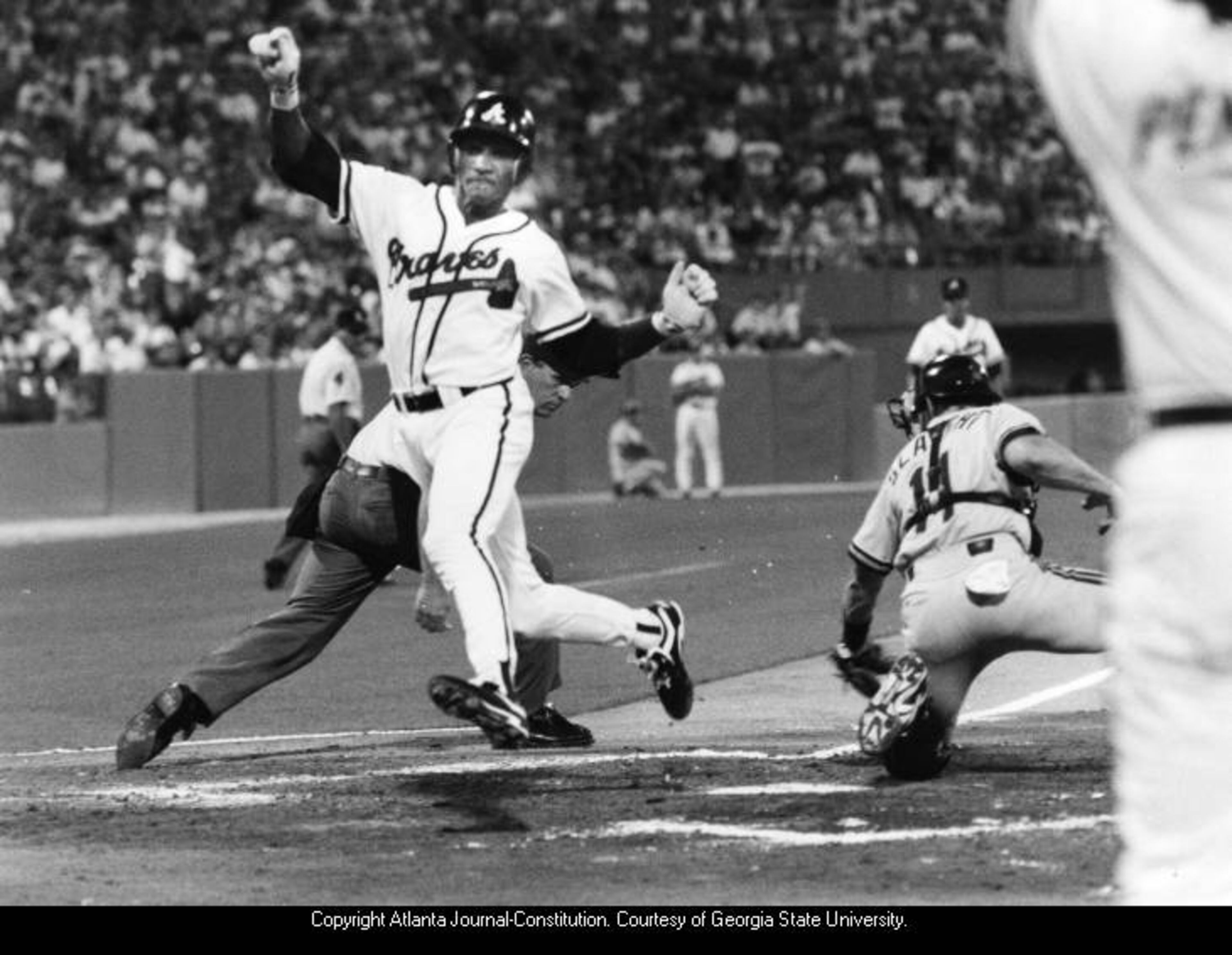 1993 -- Braves center fielder Otis Nixon scores a run during a Pirates game. JONATHAN NEWTON / AJC FILE