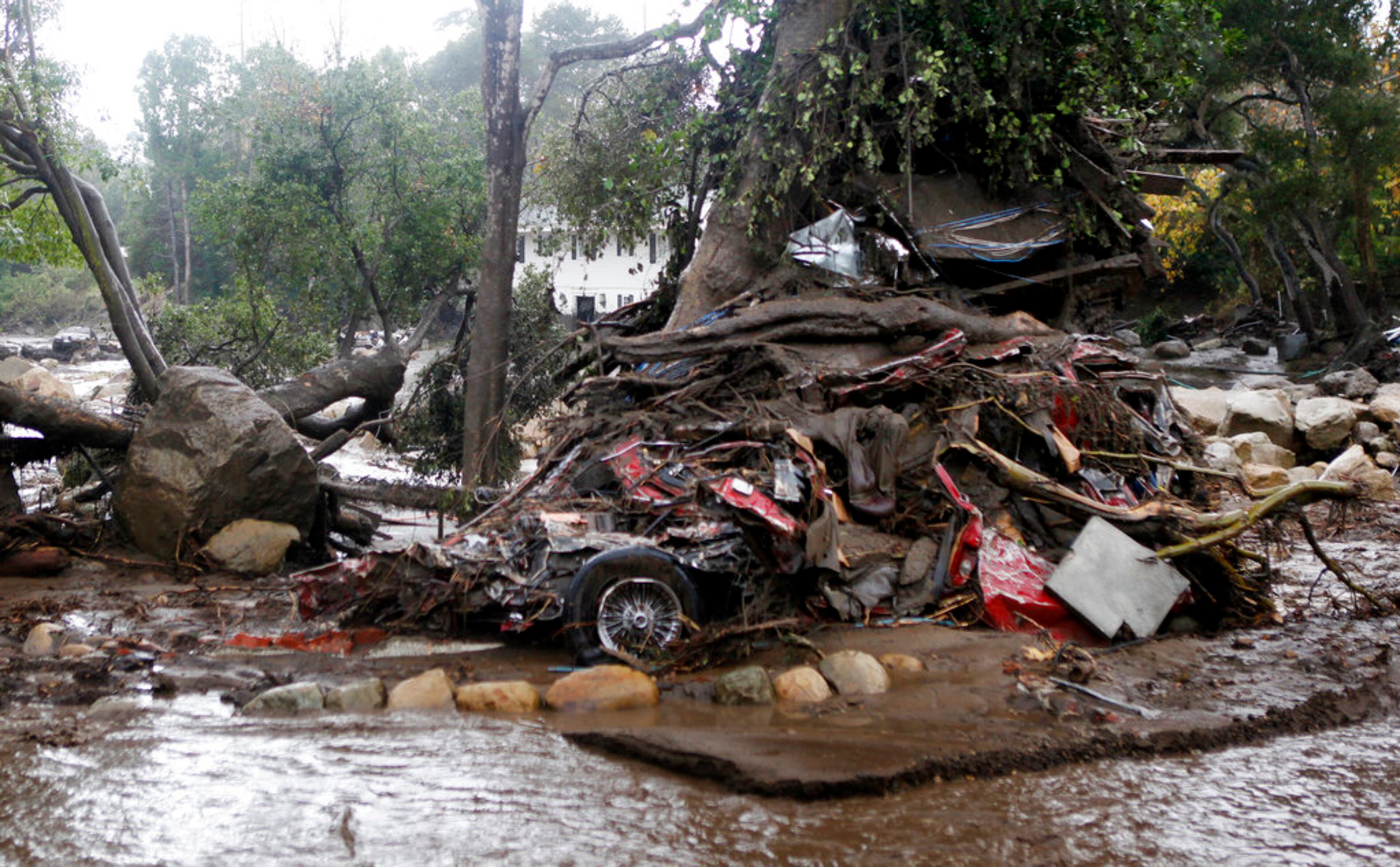 A car and debris smashed against a tree along Hot Springs Road in Montecito, Calif. Heavy rain brought flash flooding and mudslides to the area in Montecito, Calif. on Tuesday, January 9, 2018. At least five people were killed and homes were swept from their foundations Tuesday as heavy rain sent mud and boulders sliding down hills stripped of vegetation by a gigantic wildfire that raged in Southern California last month. (Daniel Dreifuss)
