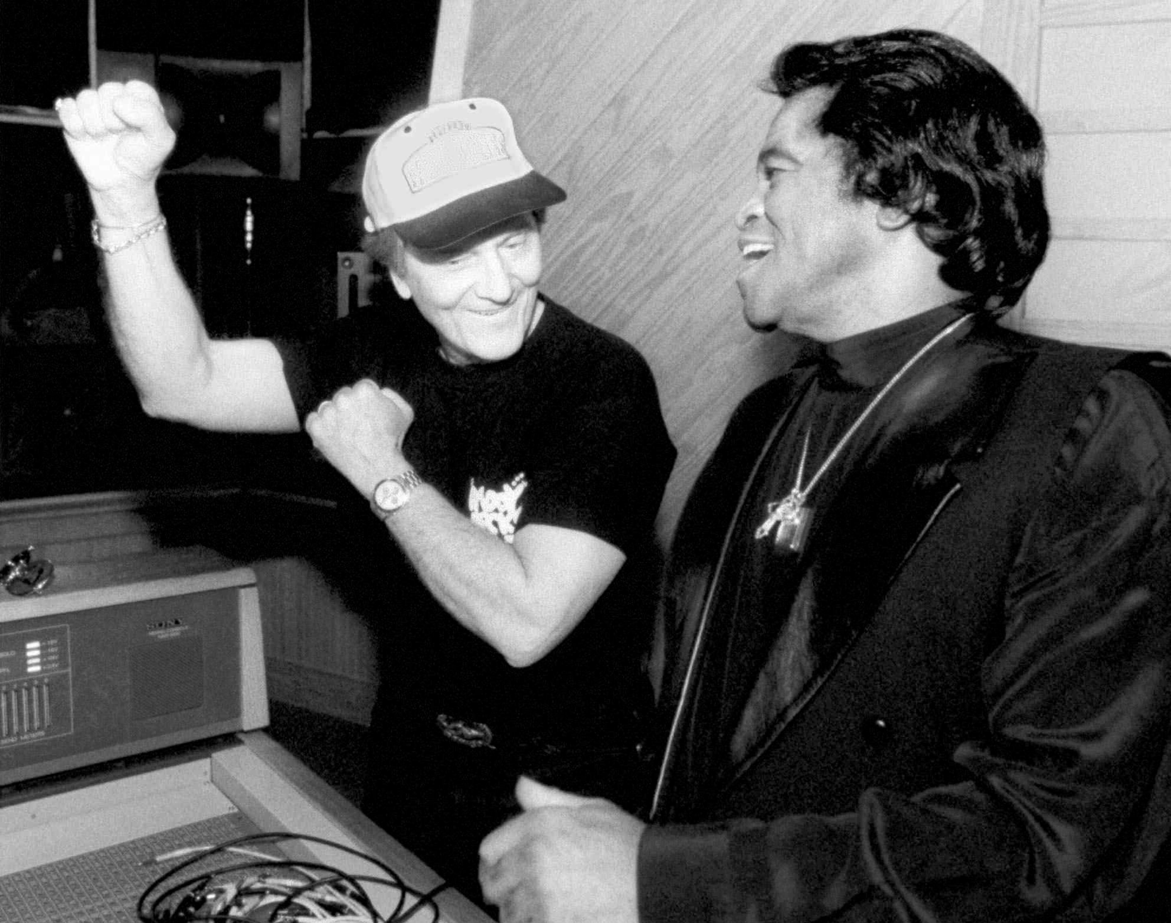 Legendary singers Pat Boone, left, and James Brown, the 'Godfather of Soul,' joke around as they listen to sound tracks before heading into the studio to record 'Papa's got a Brand New Bag' Monday, April 13, 1998, at Studio South in Augusta, Ga. Boone was recording an album of classic R&B hits with the original artist. (AP Photo/Augusta Chronicle,Brant Sanderlin)
