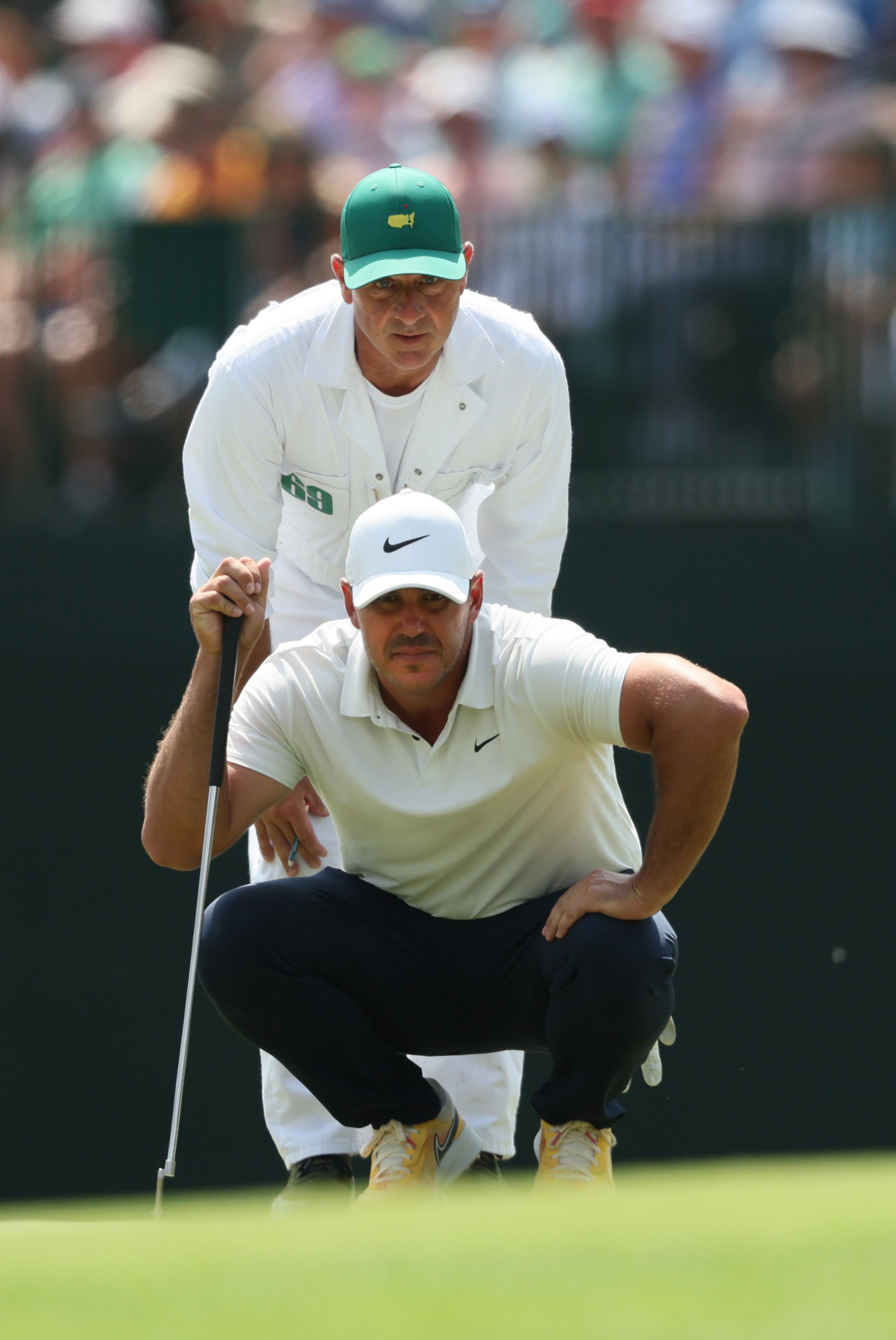 Brooks Koepka and caddie Ricky Elliott line up putt on15th green during second round of the 2023 Masters Tournament at Augusta National Golf Club, Friday, April 7, 2023, in Augusta, Ga. (Jason Getz / Jason.Getz@ajc.com)