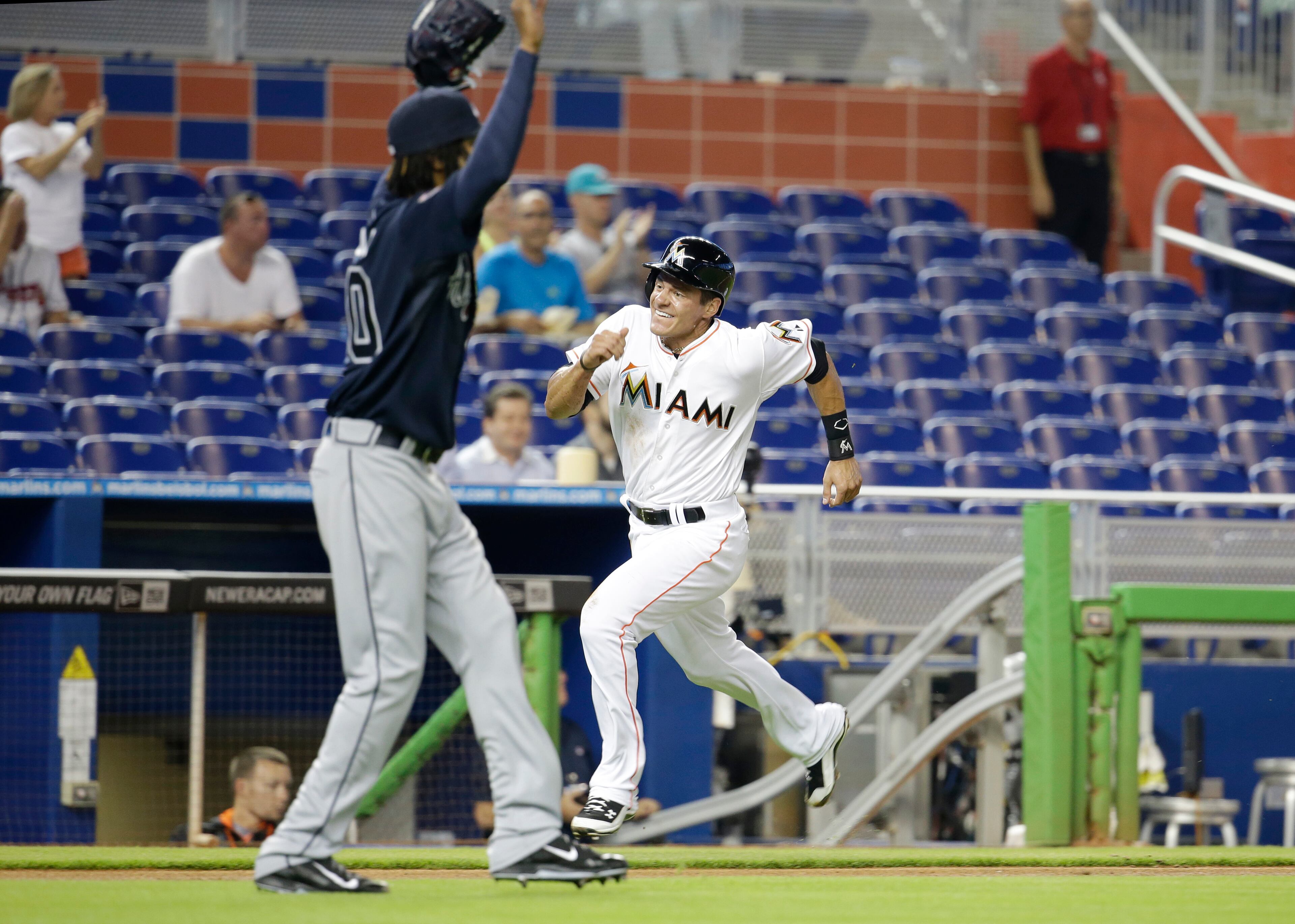 Miami Marlins' Derek Dietrich, right, runs past Atlanta Braves starting pitcher Ervin Santana, left, to score on a double by Casey McGehee in the first inning of a baseball game, Thursday, May 1, 2014, in Miami. (AP Photo/Lynne Sladky)