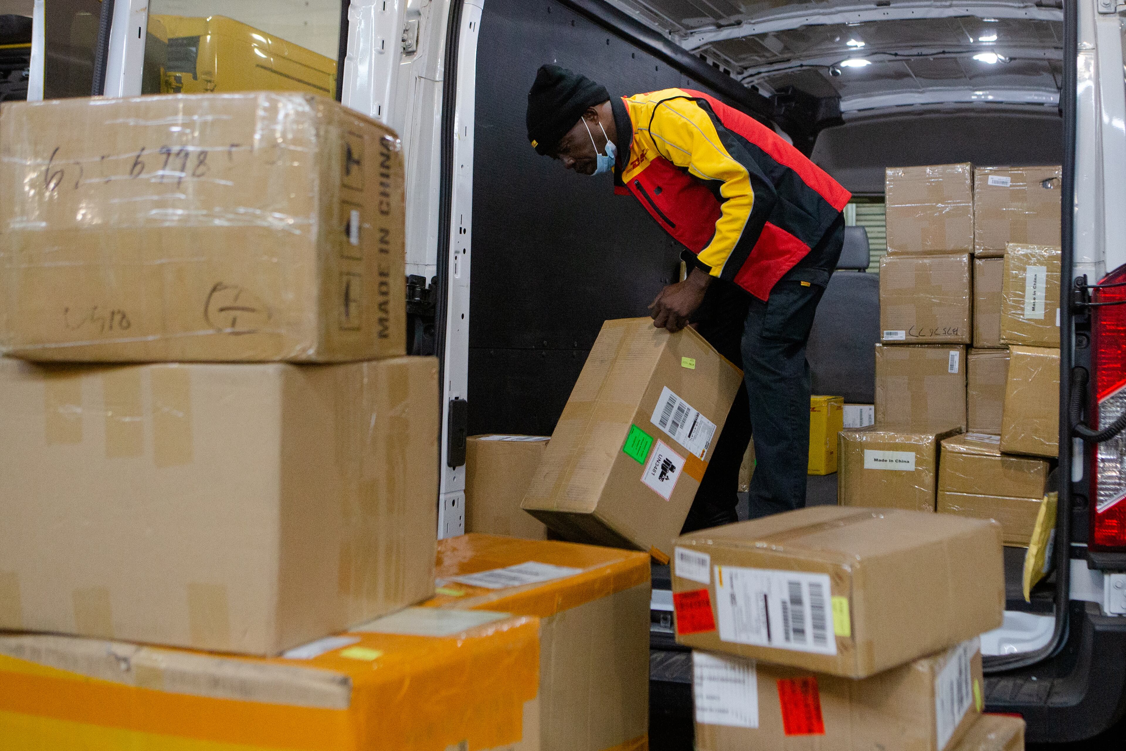 Babatunde Anezi sorts packages on Wednesday, December 16, 2020, at DHL Express in Atlanta. Workers at the shipping center worked to fulfill orders during the holiday rush. CHRISTINA MATACOTTA FOR THE ATLANTA JOURNAL-CONSTITUTION.