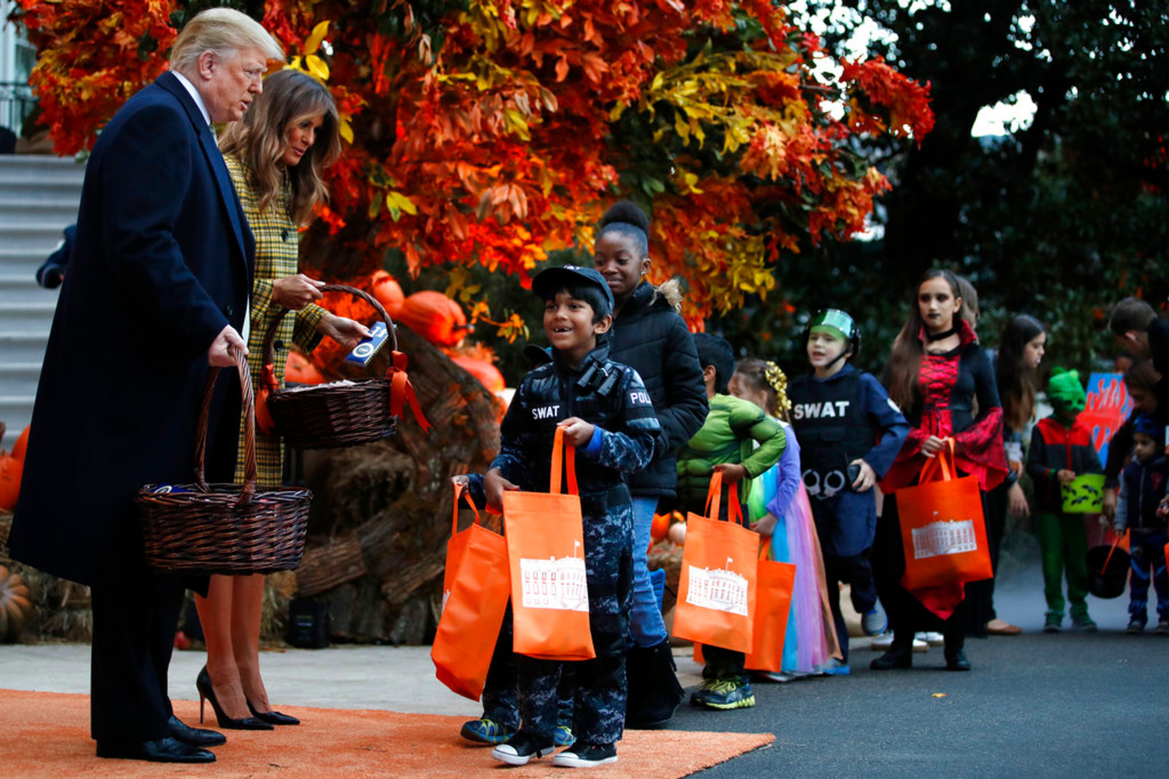 President Donald Trump and first lady Melania Trump give candy to children during a Halloween trick-or-treat event at the White House, Sunday, Oct. 28, 2018, in Washington. (AP Photo/Jacquelyn Martin)