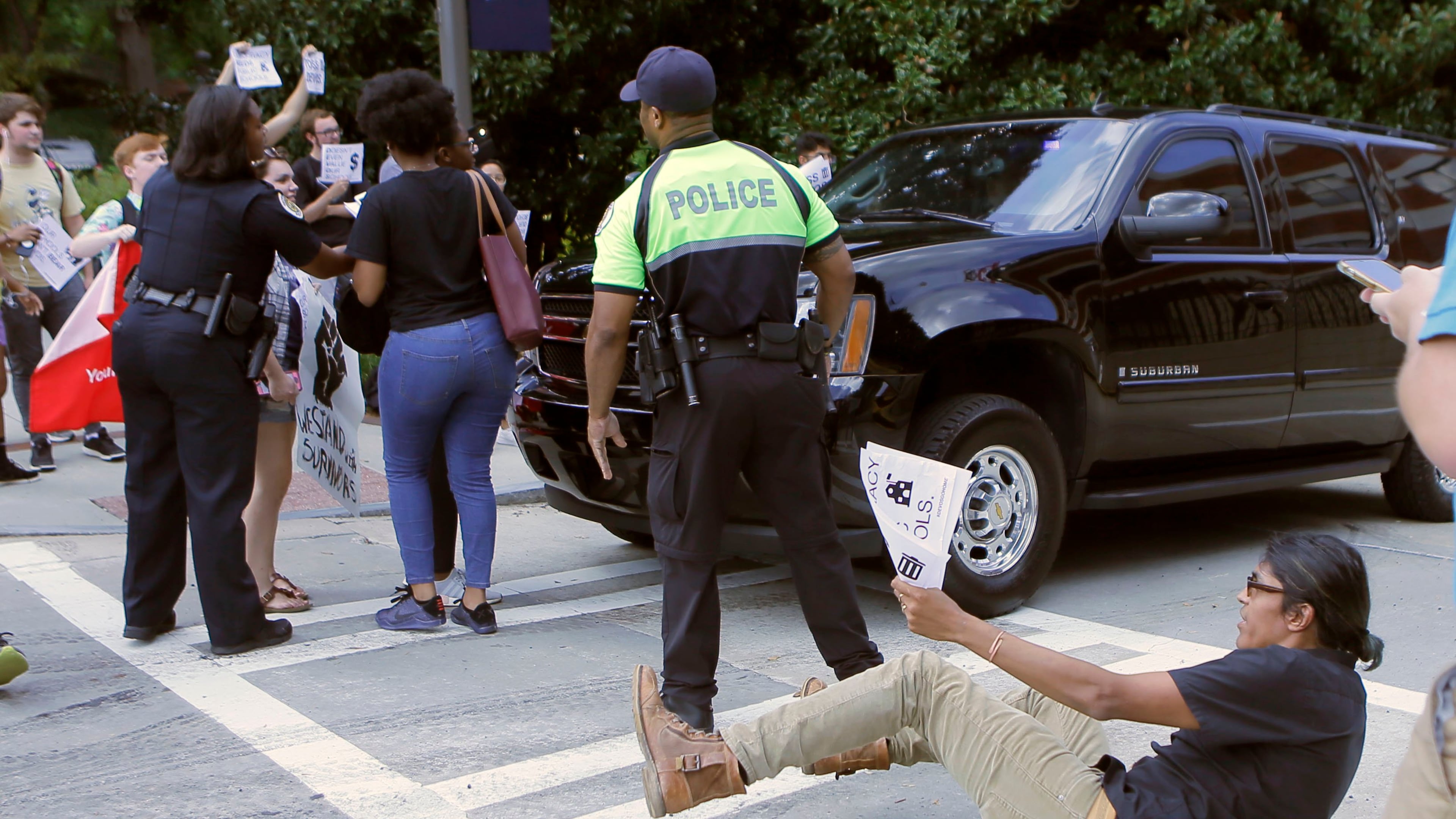 Police try to keep student protestors clear of U.S. Education Department Secretary Betsy DeVos' departing motorcade after she visited Georgia Tech in October. Students attempted to block her car, but police moved quickly to remove students from her path.