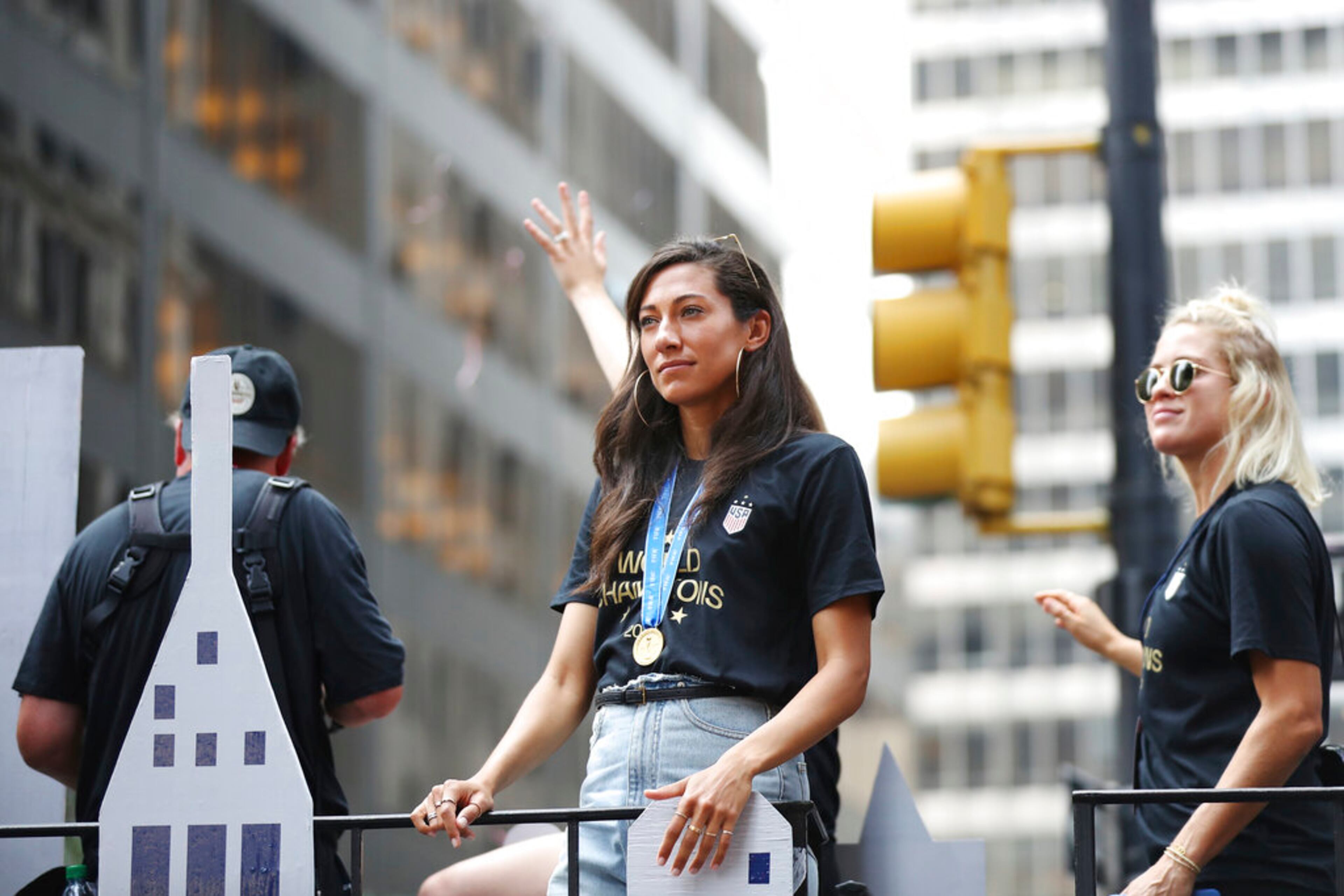 United States forward Christen Press, center, and United States defender Abby Dahlkemper look out to the crowd on a float while being honored with a ticker tape parade along the Canyon of Heroes, Wednesday, July 10, 2019, in New York. The U.S. national team beat the Netherlands 2-0 to capture a record fourth Women's World Cup title. (AP Photo/Steve Luciano)