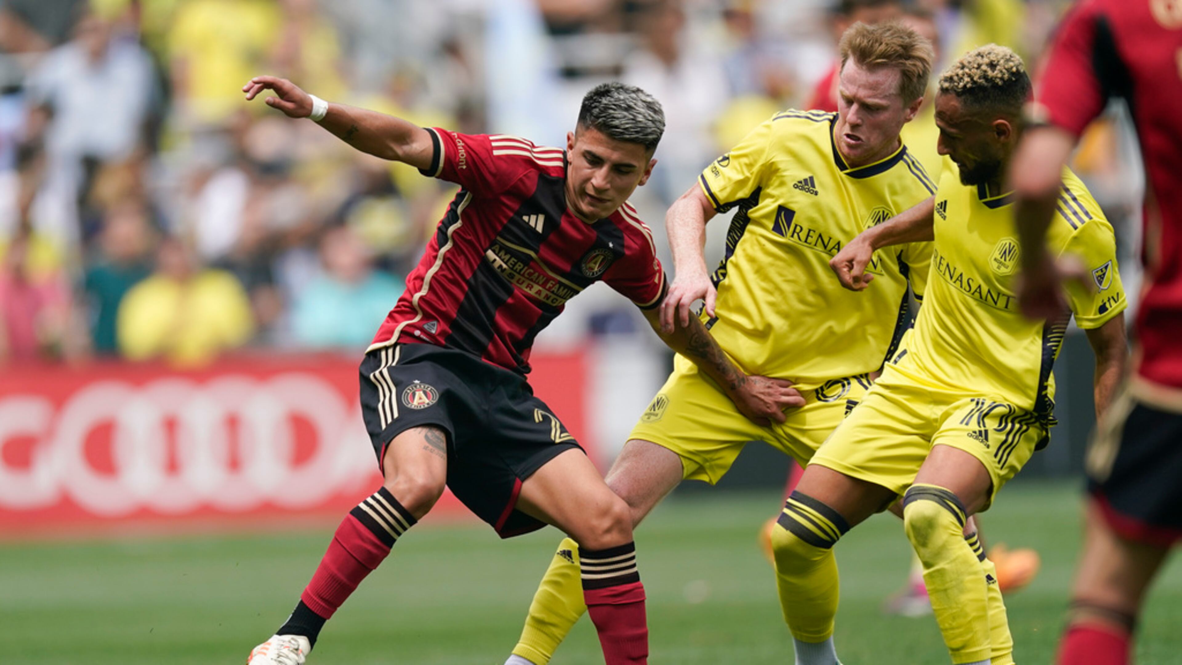 Atlanta United midfielder Thiago Almada, left, moves the ball past Nashville SC midfielder Dax McCarty, center, and midfielder Hany Mukhtar (10) during the second half of an MLS soccer match Saturday, April 29, 2023, in Nashville, Tenn. (AP Photo/George Walker IV)