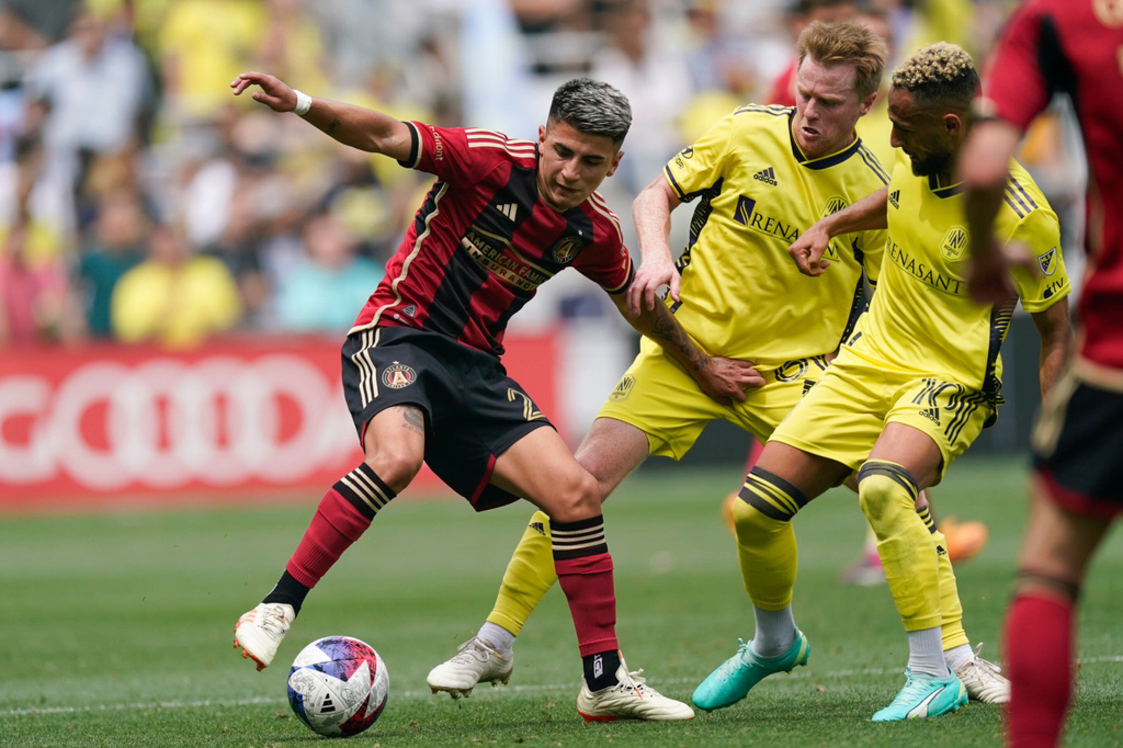 Atlanta United midfielder Thiago Almada, left, moves the ball past Nashville SC midfielder Dax McCarty, center, and midfielder Hany Mukhtar (10) during the second half of an MLS soccer match Saturday, April 29, 2023, in Nashville, Tenn. (AP Photo/George Walker IV)