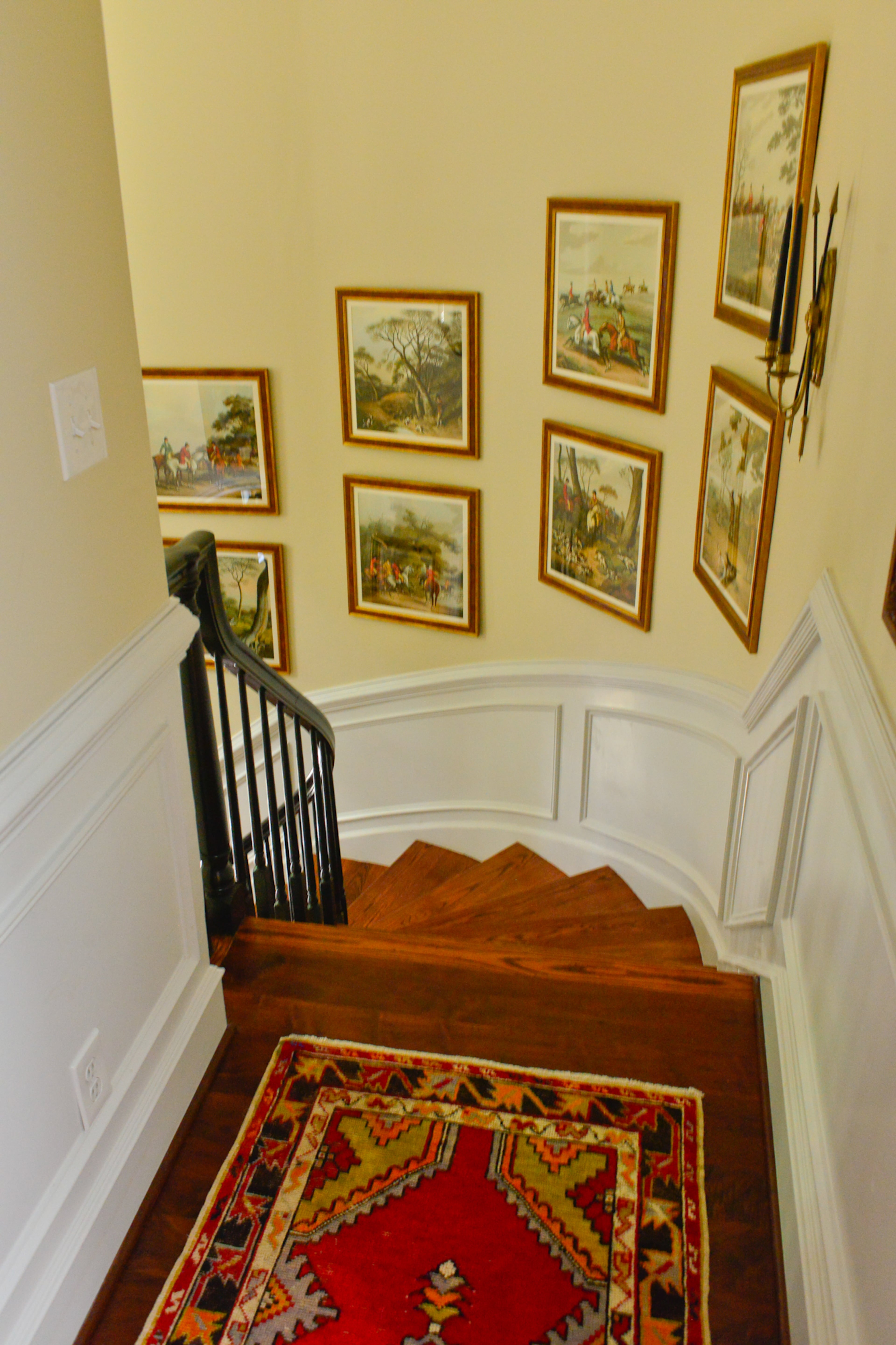A circular gallery wall features traditionally Southern paintings. Most of the artwork in the home came from Atlanta Decorative Arts Center or estate sales in Georgia. Rice says these hunting scenes add a masculine touch to the decor.