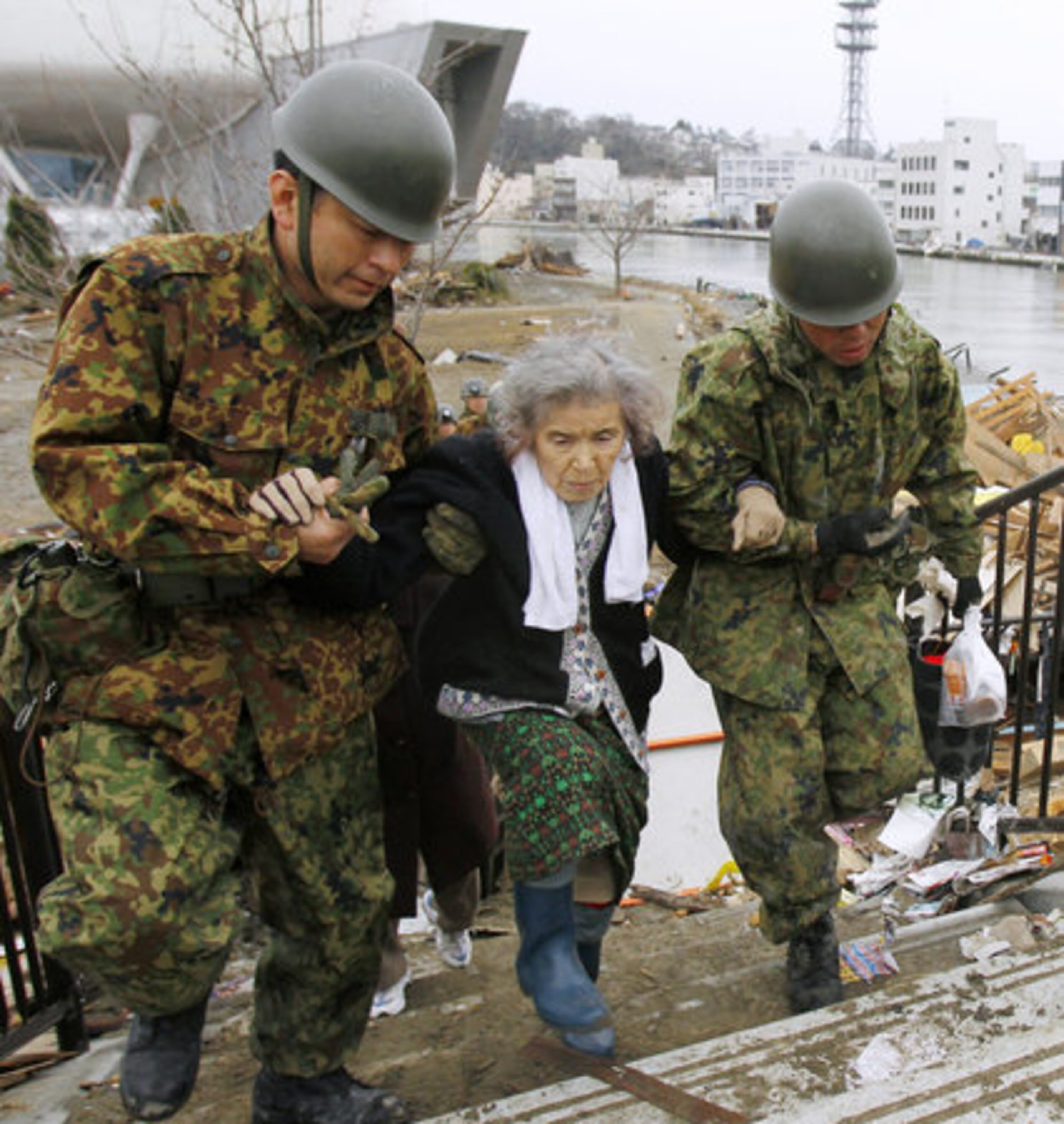 Fujiko Chiba, who was stranded in an isolated evacuation center for five days, is rescued by Japan Ground Self-Defense Force members in Ishinomaki, Miyagi Prefecture northern Japan, Tuesday March 15, 2011.