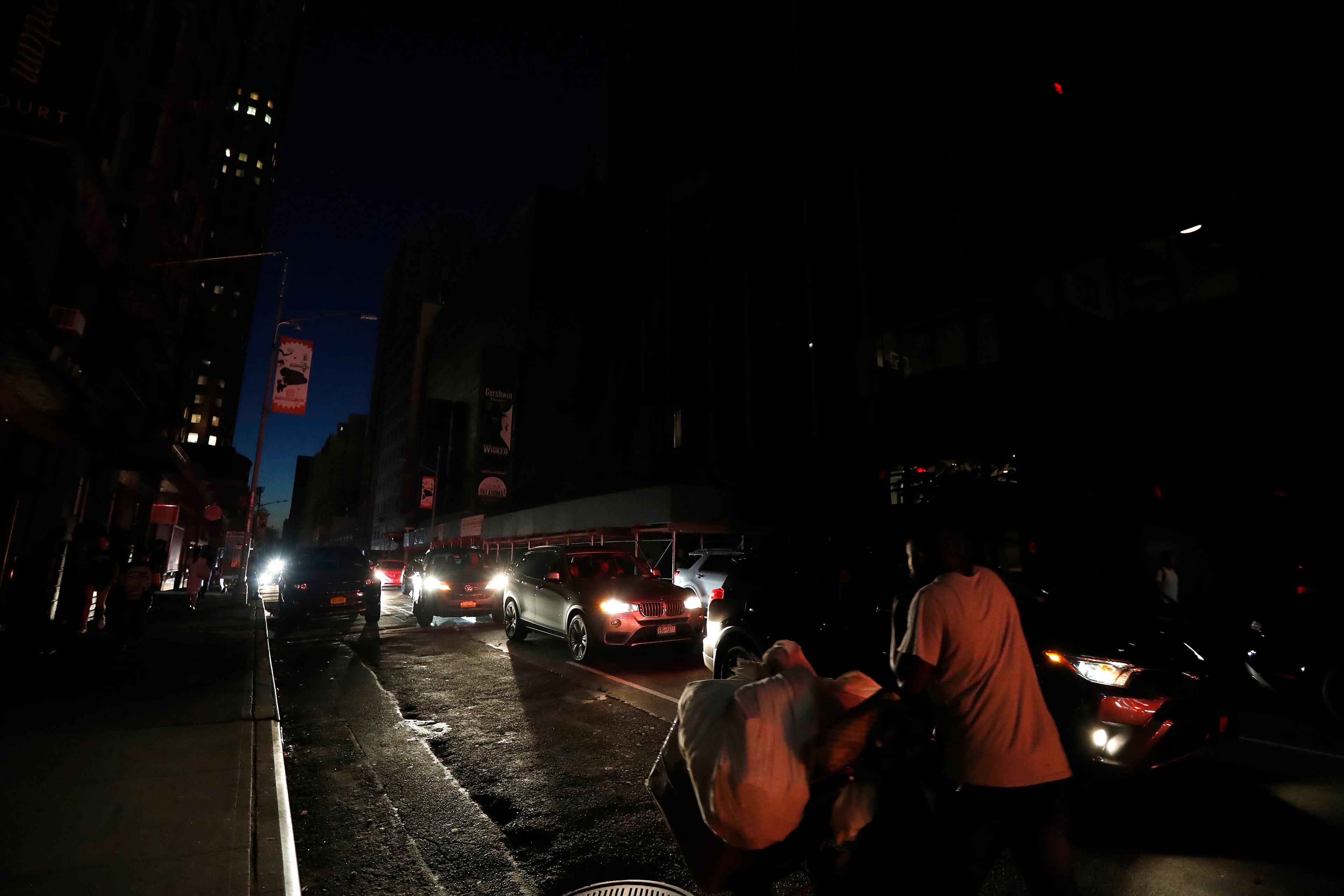 A man makes his way through a dark Times Square during a power outage, Saturday, July 13, 2019, in New York. Authorities were scrambling to restore electricity to Manhattan following a power outage that knocked out Times Square's towering electronic screens and darkened marquees in the theater district and left businesses without electricity, elevators stuck and subway cars stalled. (AP Photo/Michael Owens)