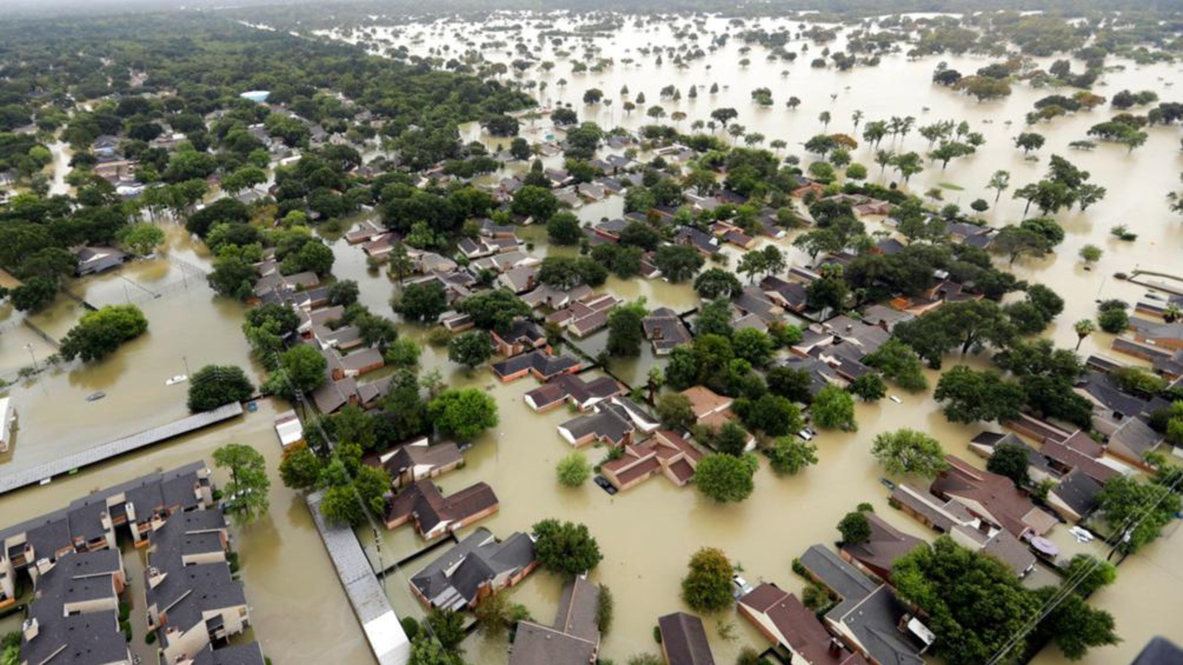 FILE - In this Tuesday, Aug. 29, 2017 file photo, water from Addicks Reservoir flows into neighborhoods as floodwaters from Tropical Storm Harvey rise in Houston. The chances of a hurricane drenching Texas, like Harvey did, have soared six fold in just a quarter century with global warming and will likely triple once again before the end of the century, says a new study published Monday, Nov. 12, 2017, in the Proceedings of the National Academy of Sciences. (AP Photo/David J. Phillip, File)
