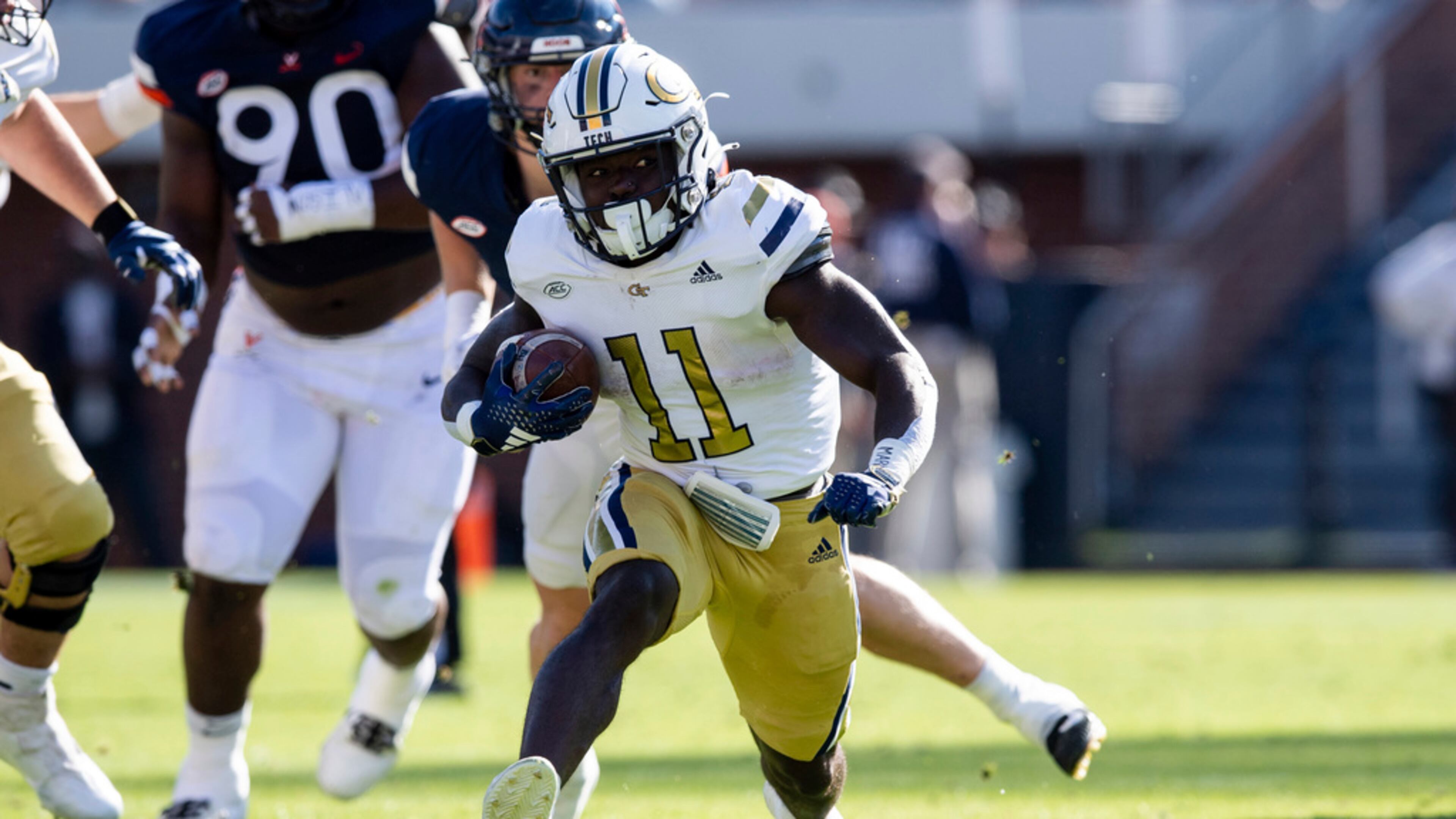 Georgia Tech running back Jamal Haynes (11) runs for a gain against the Virginia defense during the first half of an NCAA college football game Saturday, Nov. 4, 2023, in Charlottesville, Va. (AP Photo/Mike Caudill)