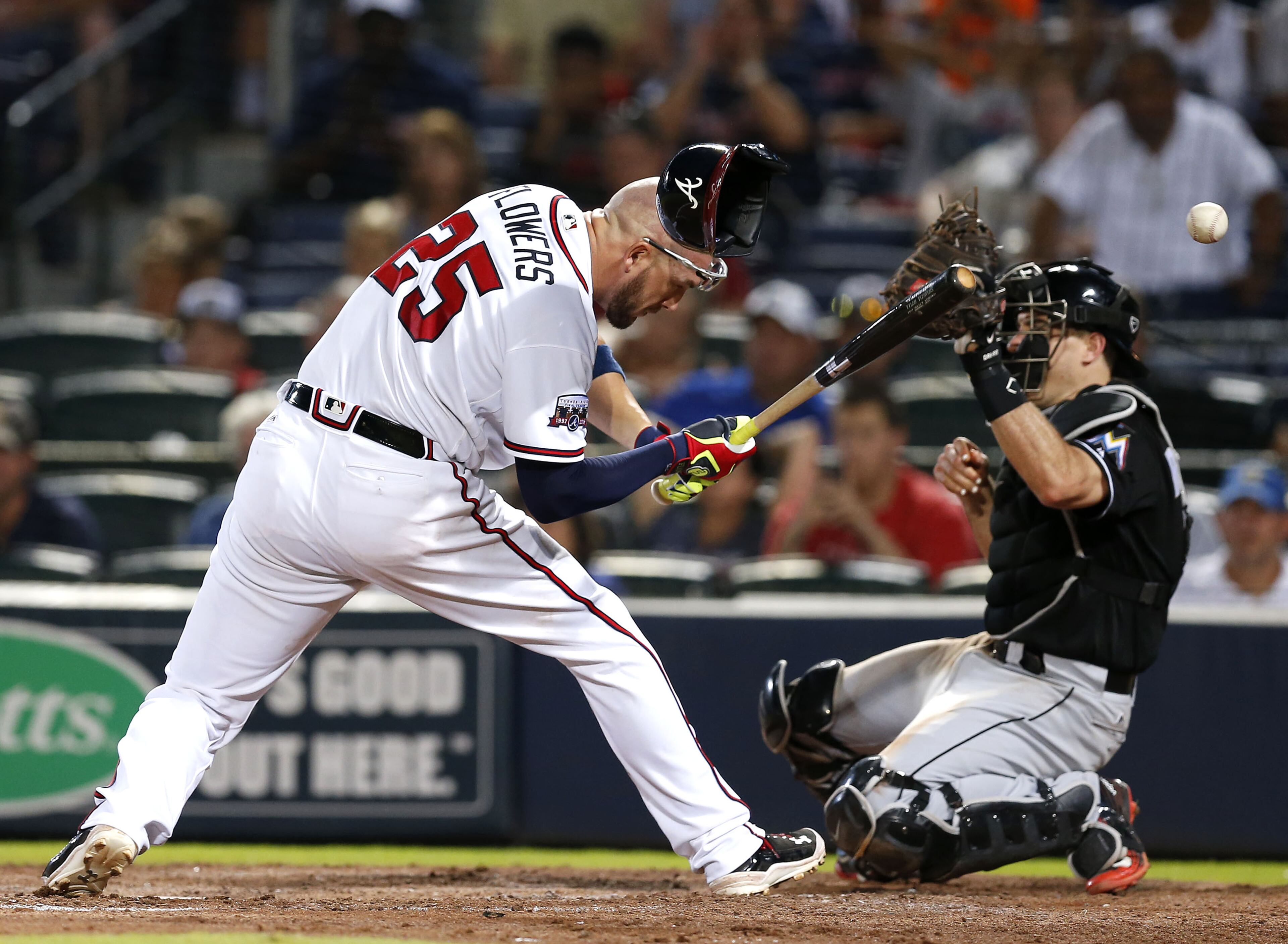 ATLANTA, GA - JULY 01: Catcher Tyler Flowers #25 of the Atlanta Braves is hit in the head with a pitch while catcher J.T. Realmuto #11 of the Miami Marlins tries to catch the ball during the tenth inning of the game at Turner Field on July 1, 2016 in Atlanta, Georgia. (Photo by Mike Zarrilli/Getty Images)