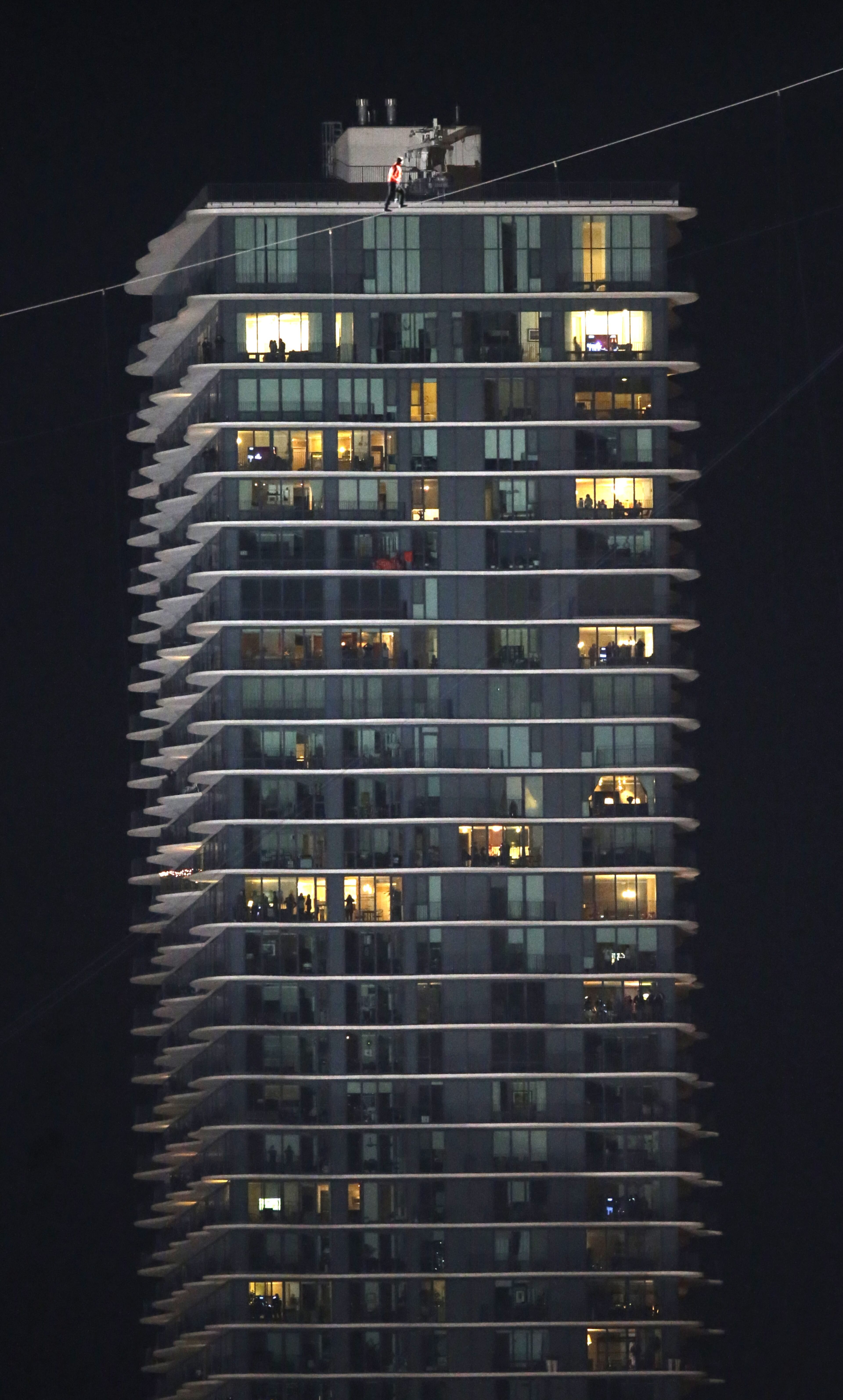 Daredevil Nik Wallenda makes his tightrope walk uphill at a 15-degree angle, from the Marina City west tower across the Chicago River to the top of the Leo Burnett Building, past the Aqua Building, background, Sunday, Nov. 2, 2014, in Chicago. (AP Photo/Charles Rex Arbogast)