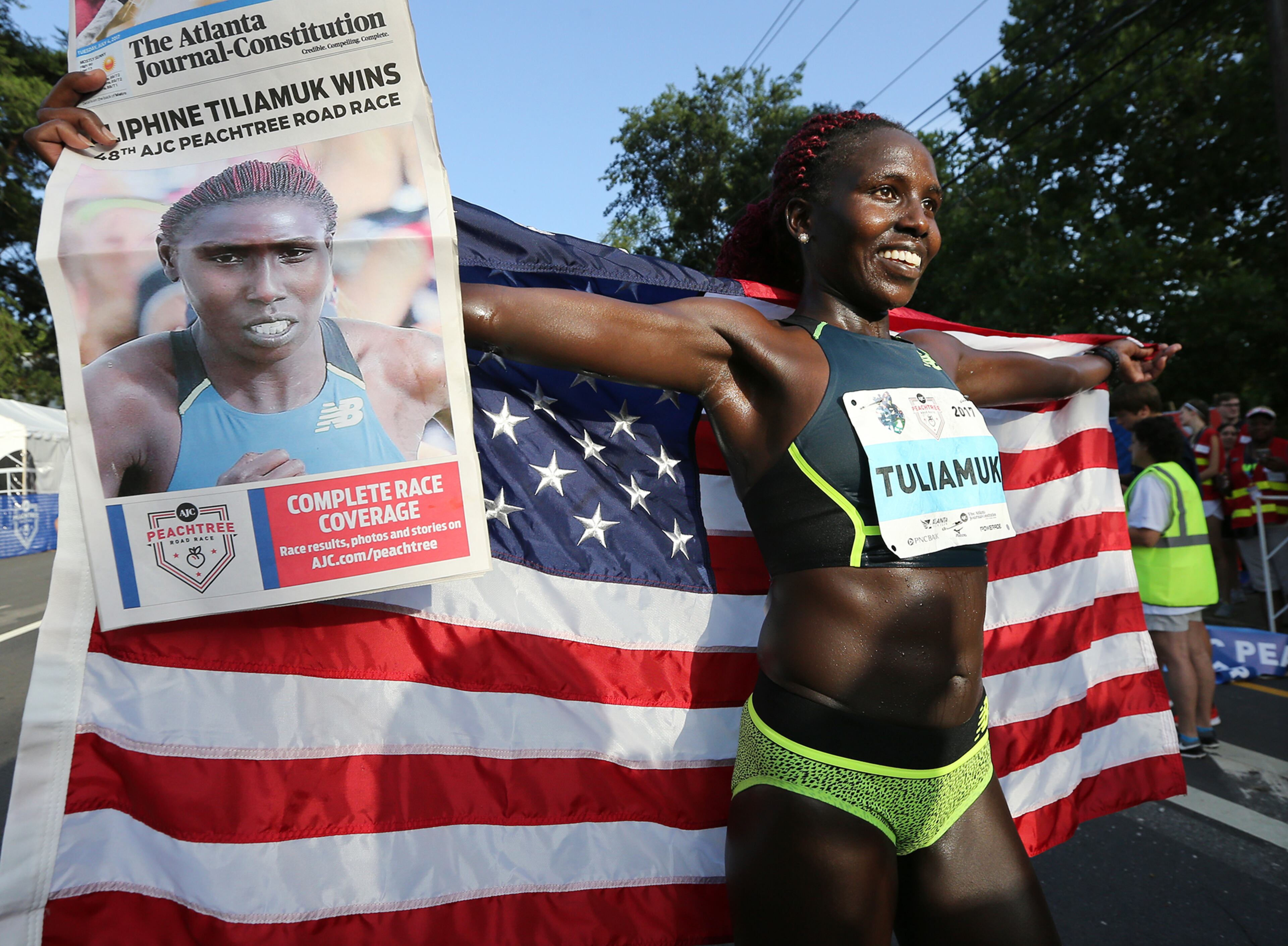 July 04, 2017 Atlanta: Aliphine Tuliamuk celebrates winning the female division with an unofficial time of 32.49 during the 48th running of the AJC Peachtree Road Race on Tuesday, July 4, 2017, in Atlanta. Curtis Compton/ccompton@ajc.com