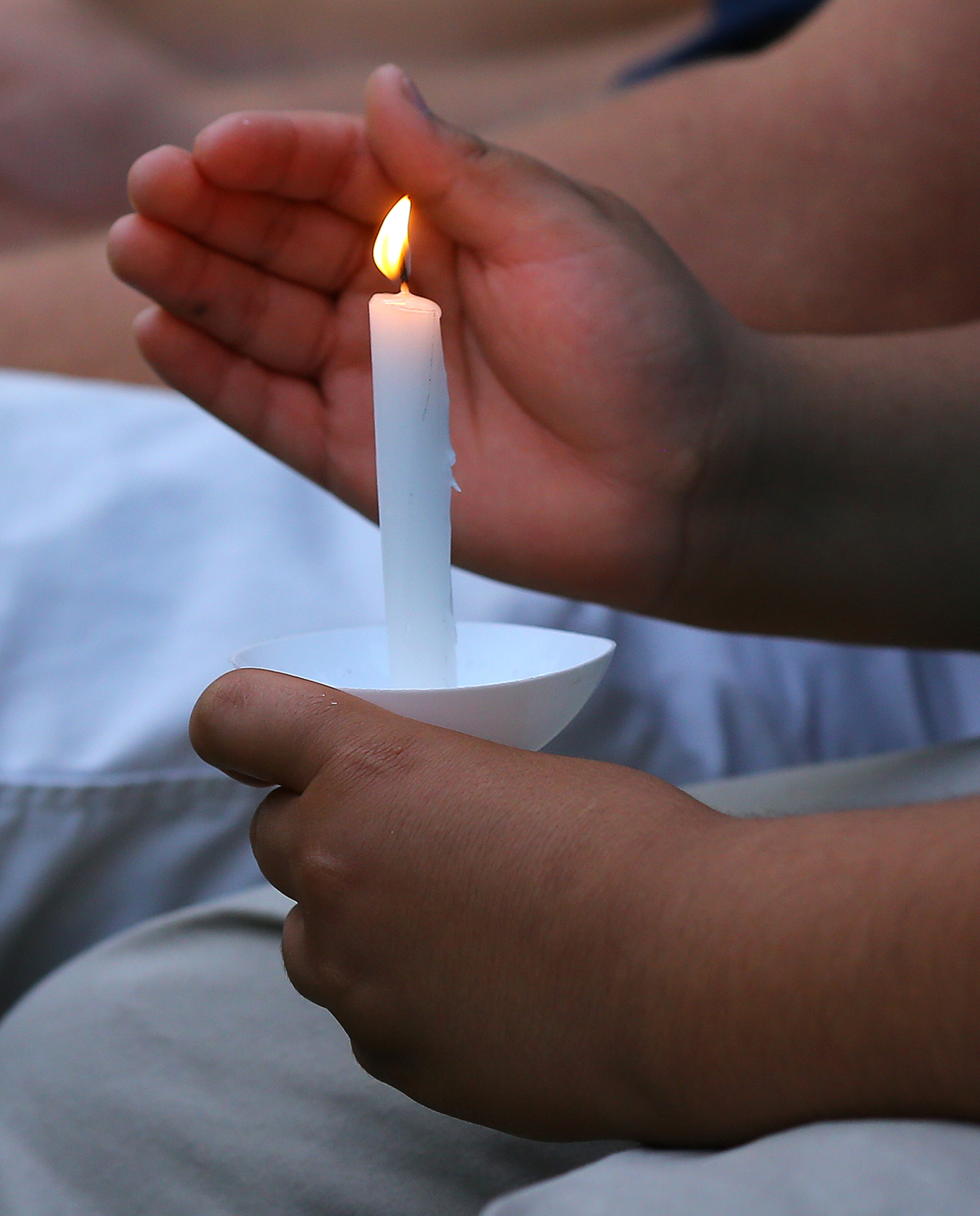 A family member holds a candle during the Memorial Service on Thursday, April 23, 2015, in Statesboro. Curtis Compton / ccompton@ajc.com