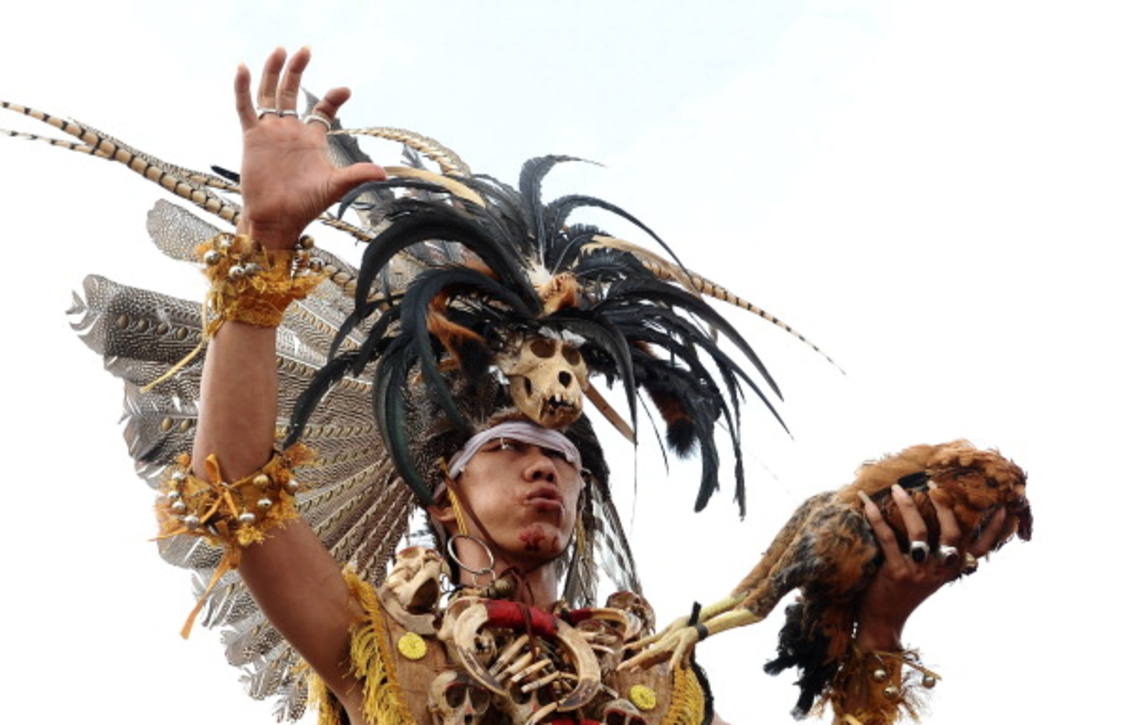 SINGKAWANG, KALIMANTAN, INDONESIA - FEBRUARY 14: A Tatung eats a chicken during Tatung Festival as part of Cap Go Meh celebration on February 14, 2014 in Singkawang, Kalimantan, Indonesia. The ancient art of Tatung, performed as part of the Cap Go Meh Festival, is believed to call upon positive spirit who help to dispel the bad spirits that may affect people's lives. Cap Go Meh Festival also know as Lantern Festival is celebrated in the 15th day of Chinese Lunar Year and marks the end of the Chinese New Year celebrations. (Photo by Robertus Pudyanto/Getty Images)