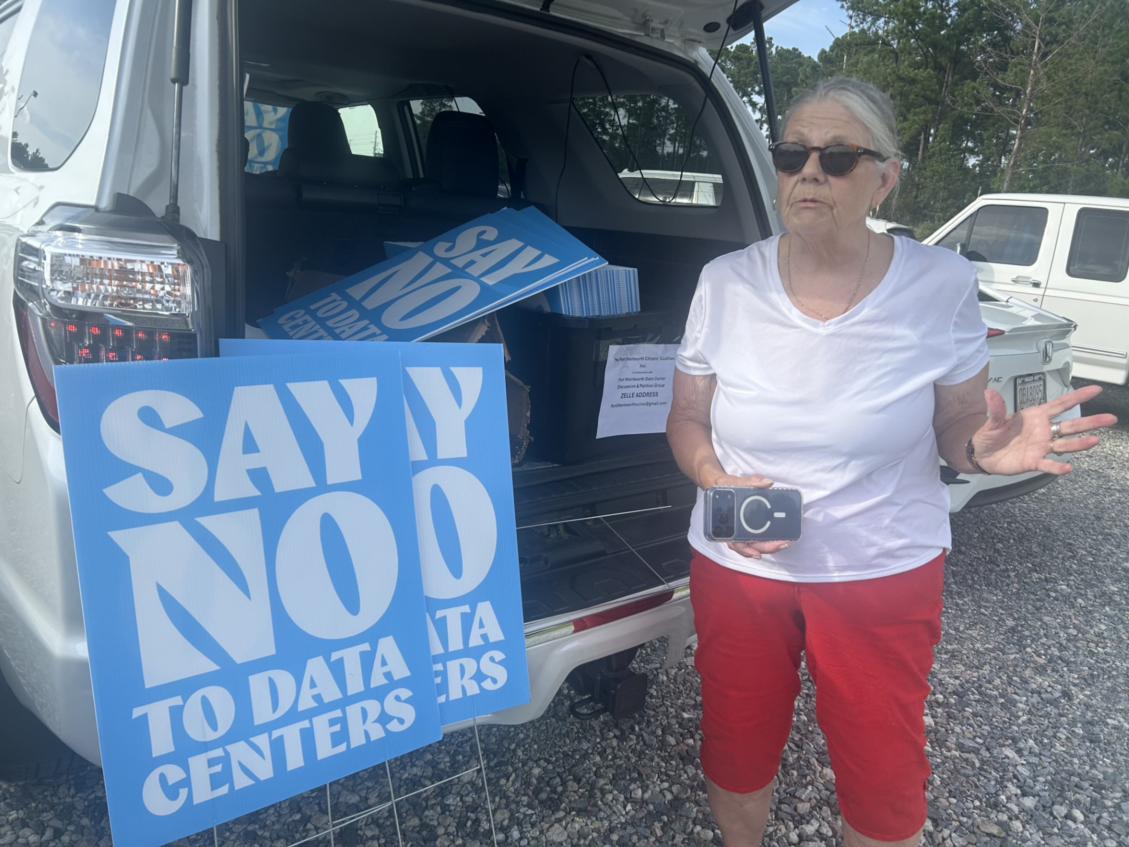 Jenny Hines makes her way to the OpenAI open house on Thursday, July 23, 2026, with yard signs to distribute to opponents of the company’s proposed data center. (Adam Van Brimmer/AJC)