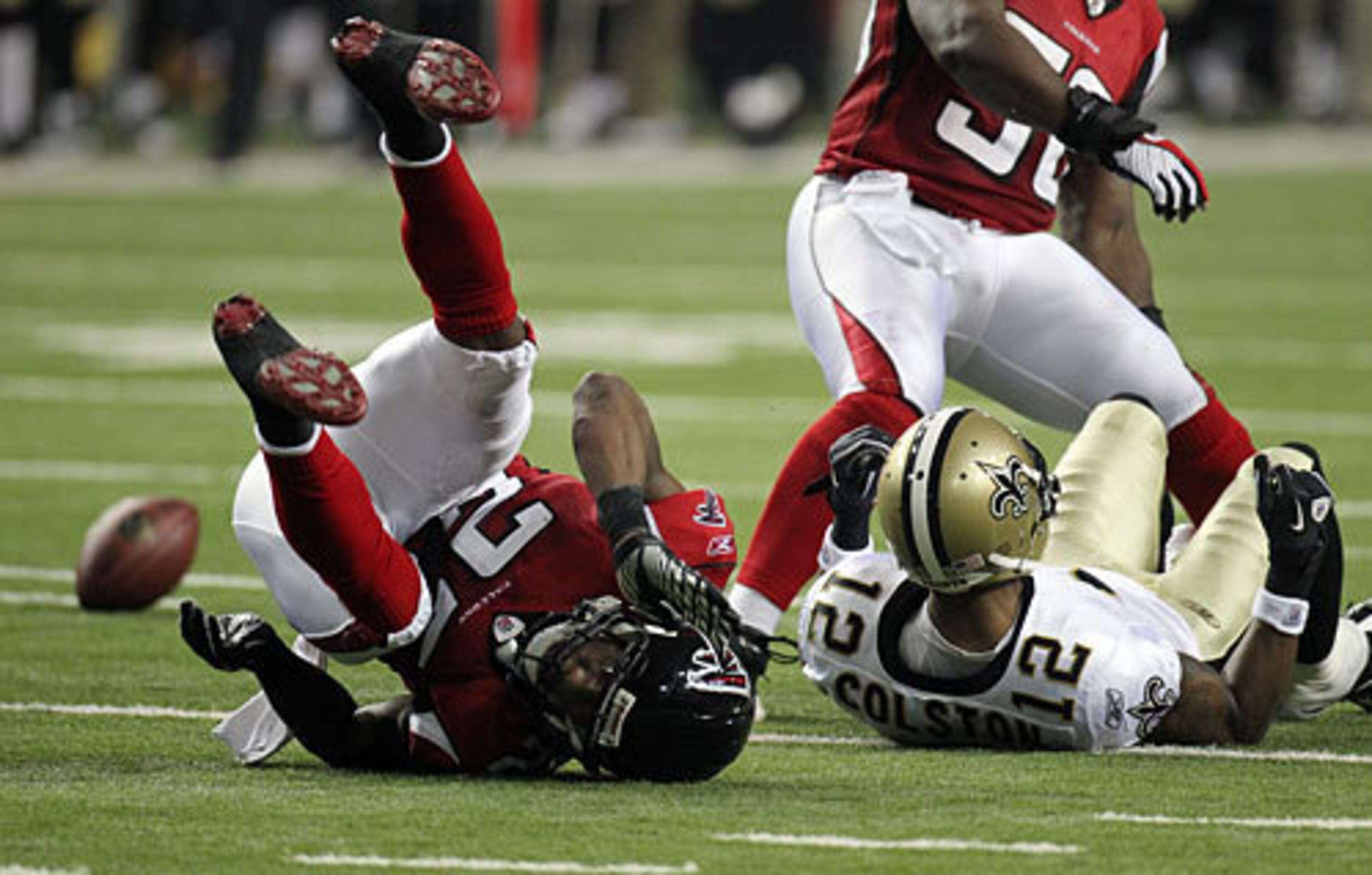 Atlanta's William Moore and New Orleans' Marques Colston hit the turf.