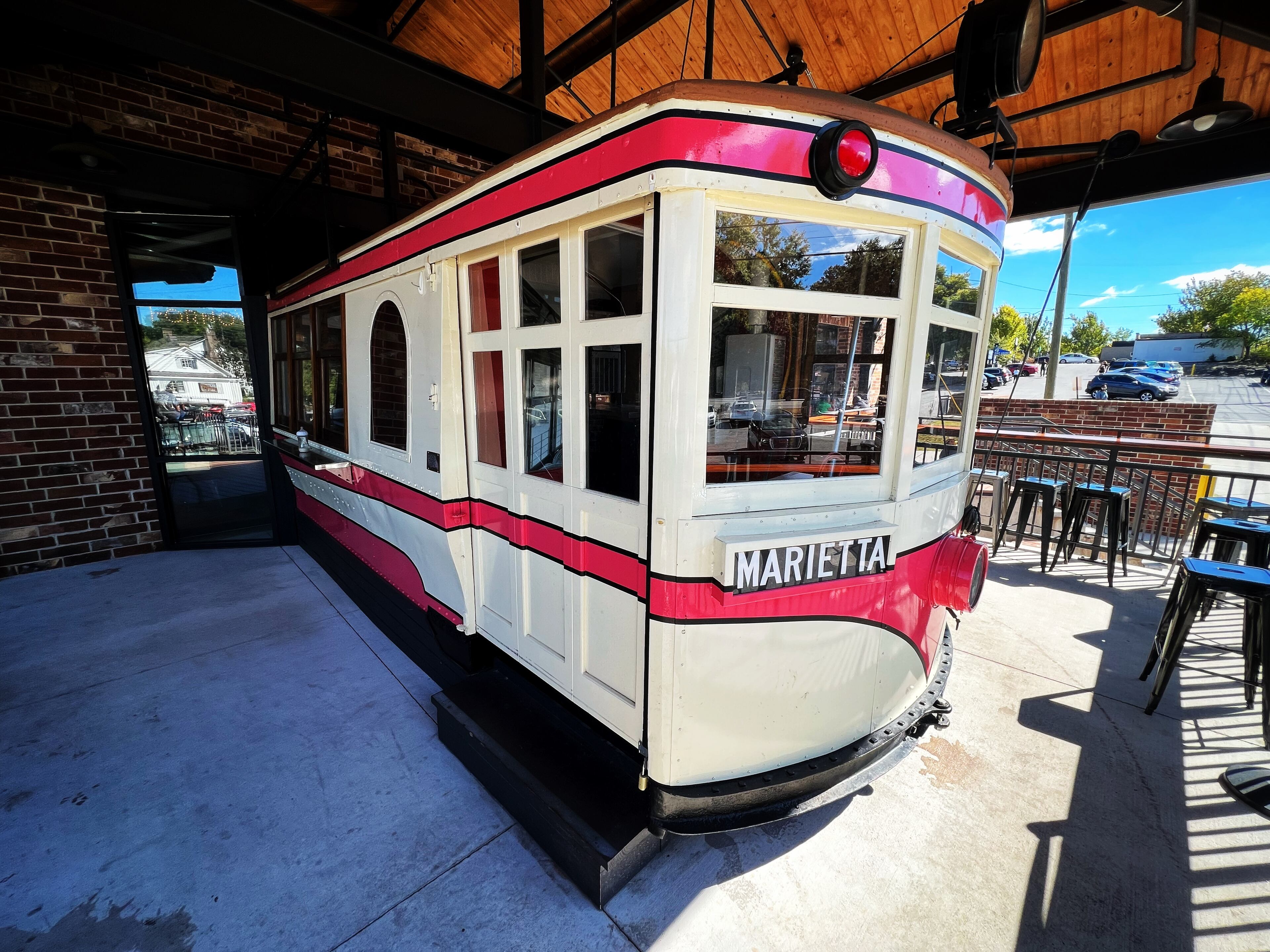 An antique trolley pokes out from the front facade of Marietta Square Market.