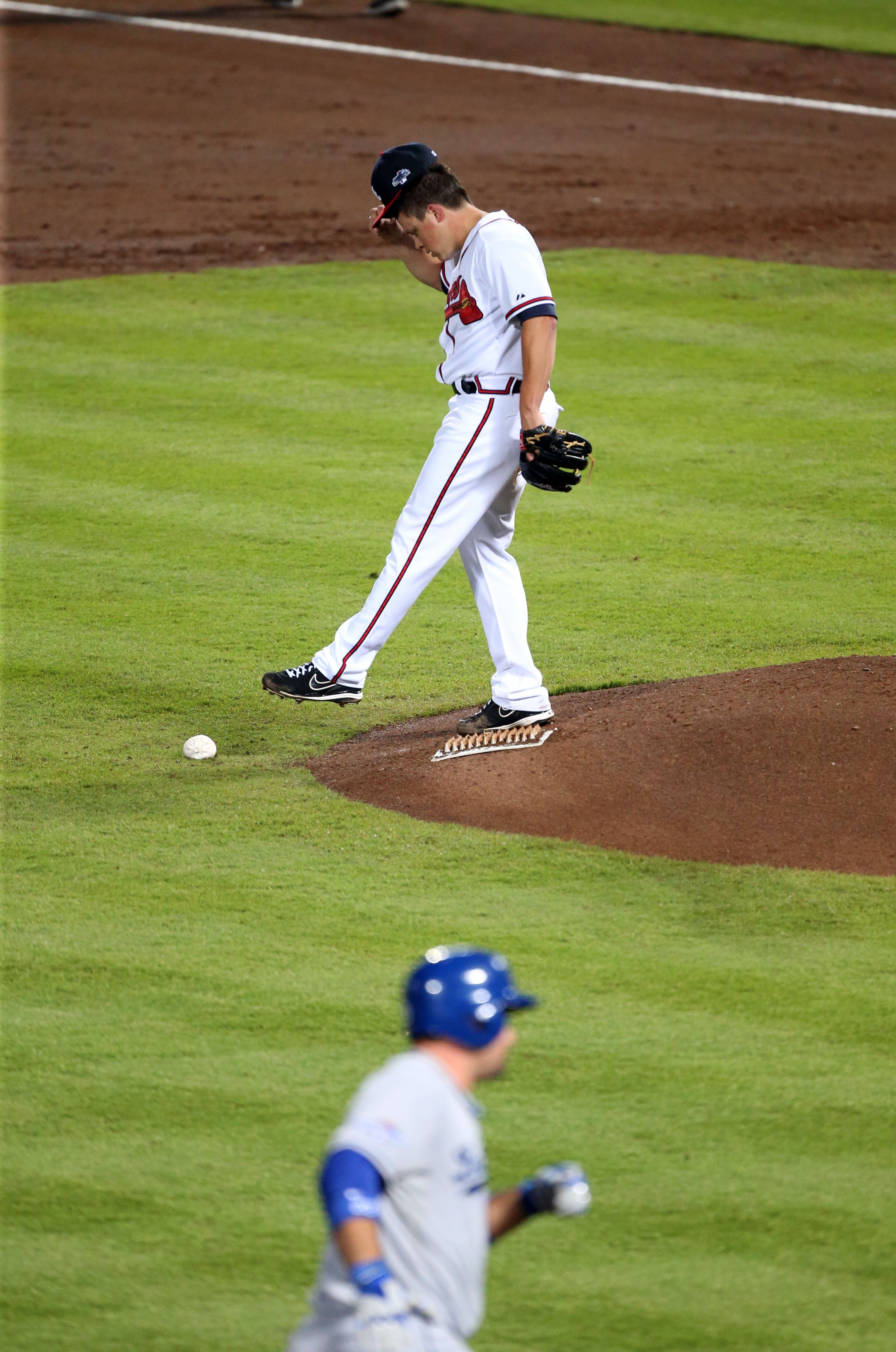 Atlanta Braves starting pitcher Kris Medlen (54) reacts to two run homer by Los Angeles Dodgers first baseman Adrian Gonzalez (23) in the 3rd inning during the first game of the National League Division series between the Los Angeles Dodgers and Atlanta Braves at Turner Field, Thursday, October 3, 2013.