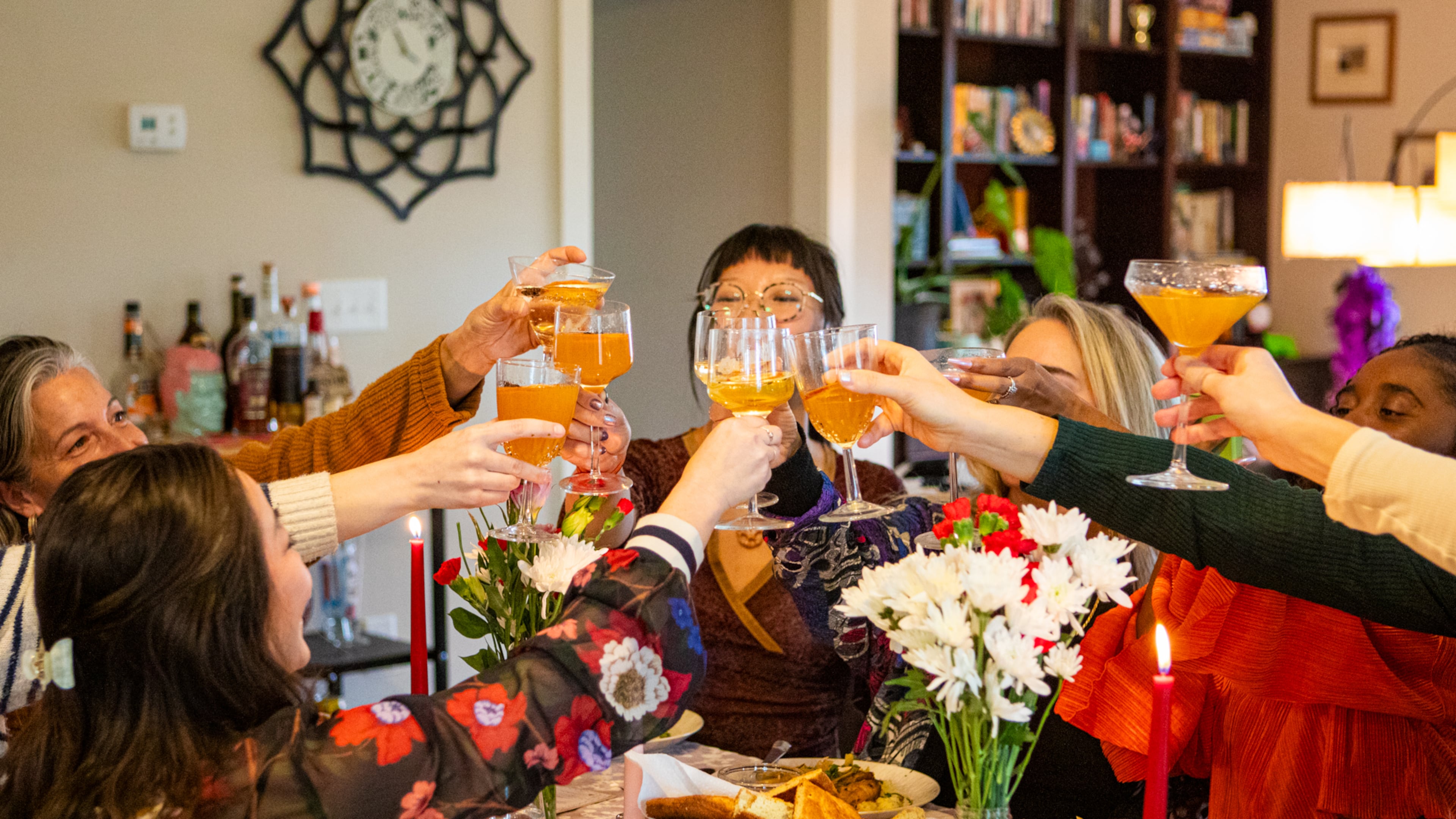 Guests cheer with their Spiced Citrus Gold cocktails at reporter Olivia Wakim's Galentine's Day supper club, featuring recipes from local food and beverage professionals. (Aaliyah Man for The Atlanta Journal-Constitution)
