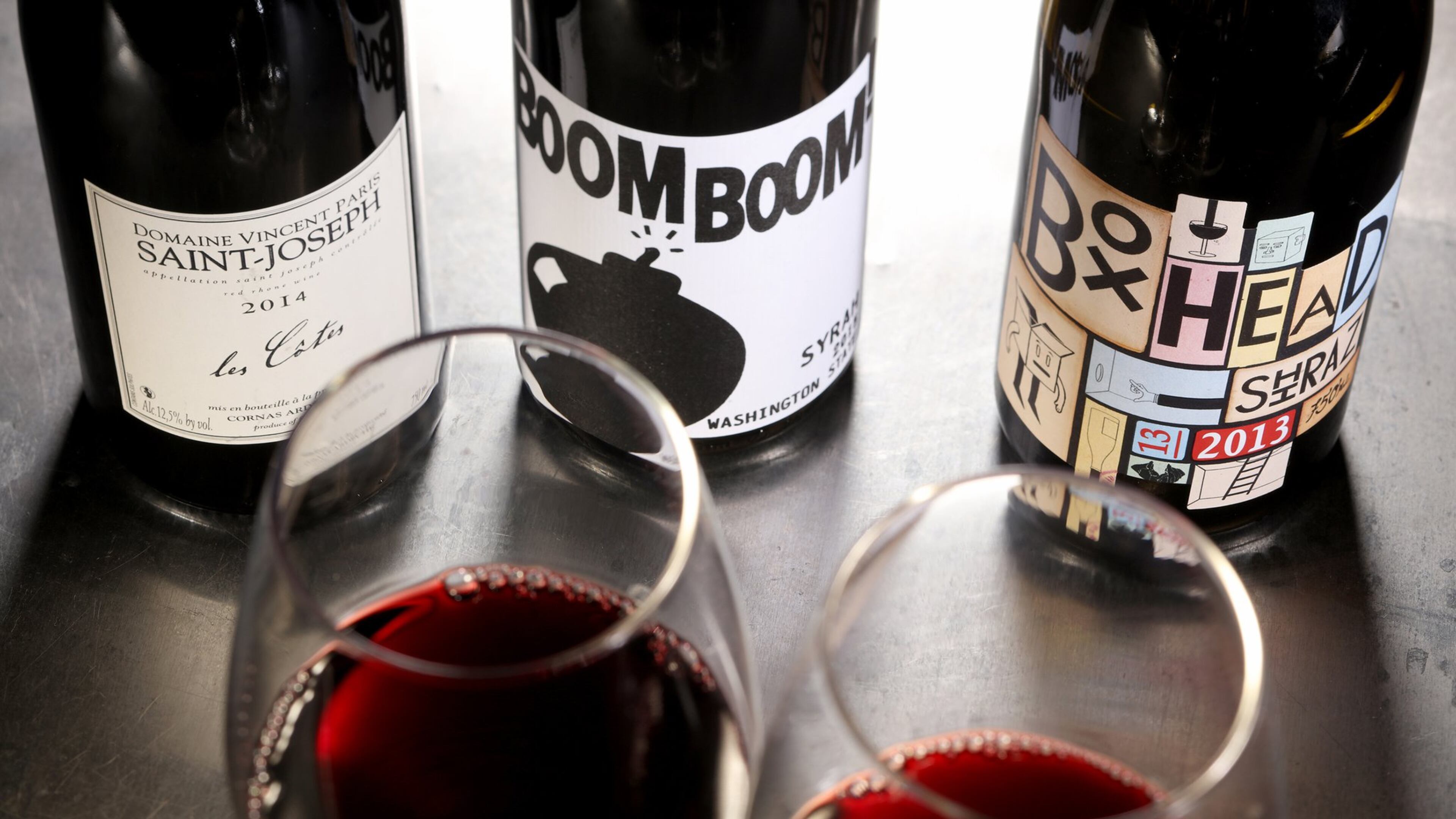 Syrah in the bottle might be called that on the label, or maybe shiraz, or maybe the grape isn’t named at all. Here we see syrah-based wines from Saint-Joseph in France, from left, Washington state and Australia. (Michael Tercha/Chicago Tribune)