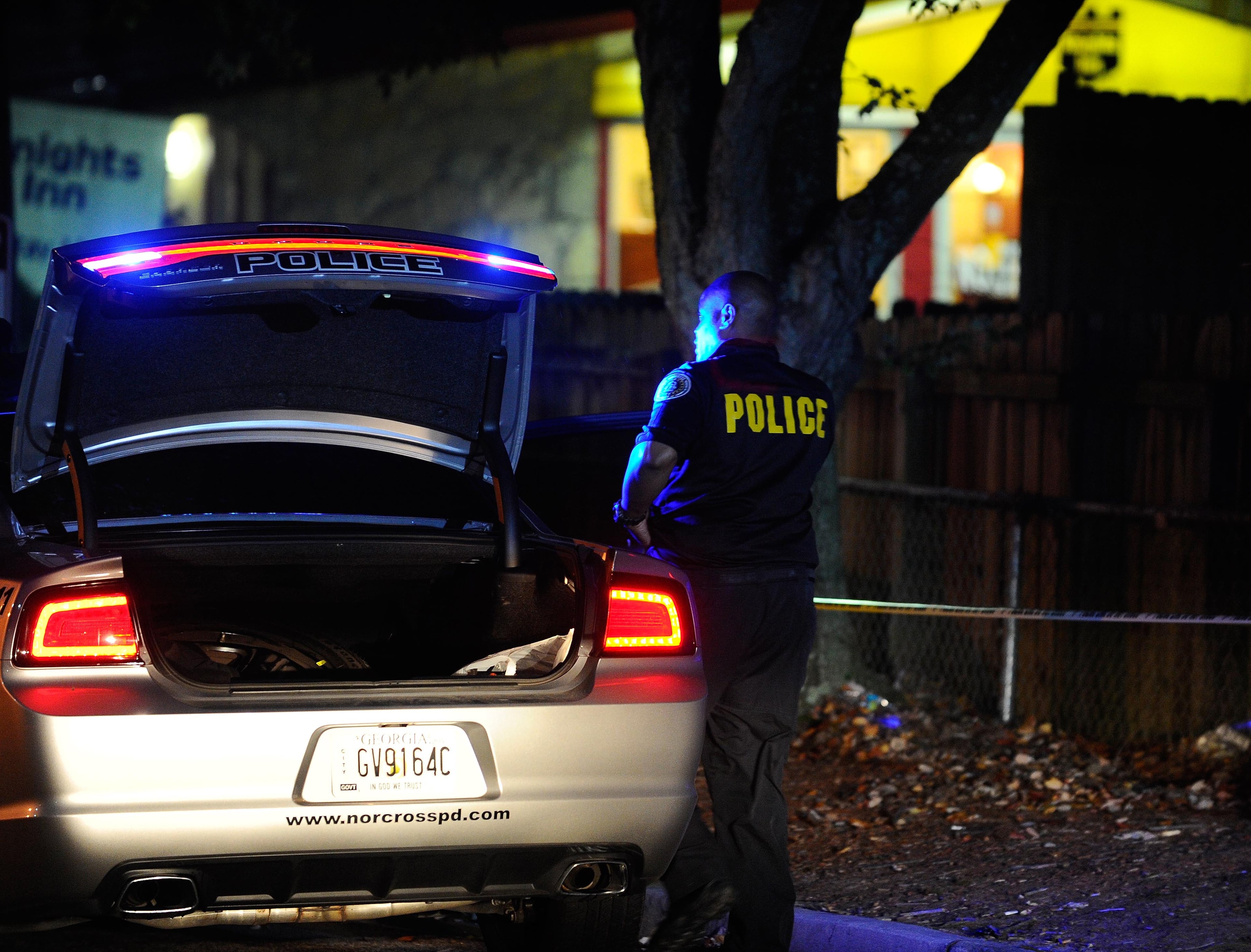 Norcross police and the GBI investigate an officer-involved shooting at the Fusion Event Hall parking lot next to a Knights Inn motel and the adjacent Waffle House at Indian Trail Road and Brook Hollow Parkway on Monday, Oct. 13, 2014, in Norcross, Ga.