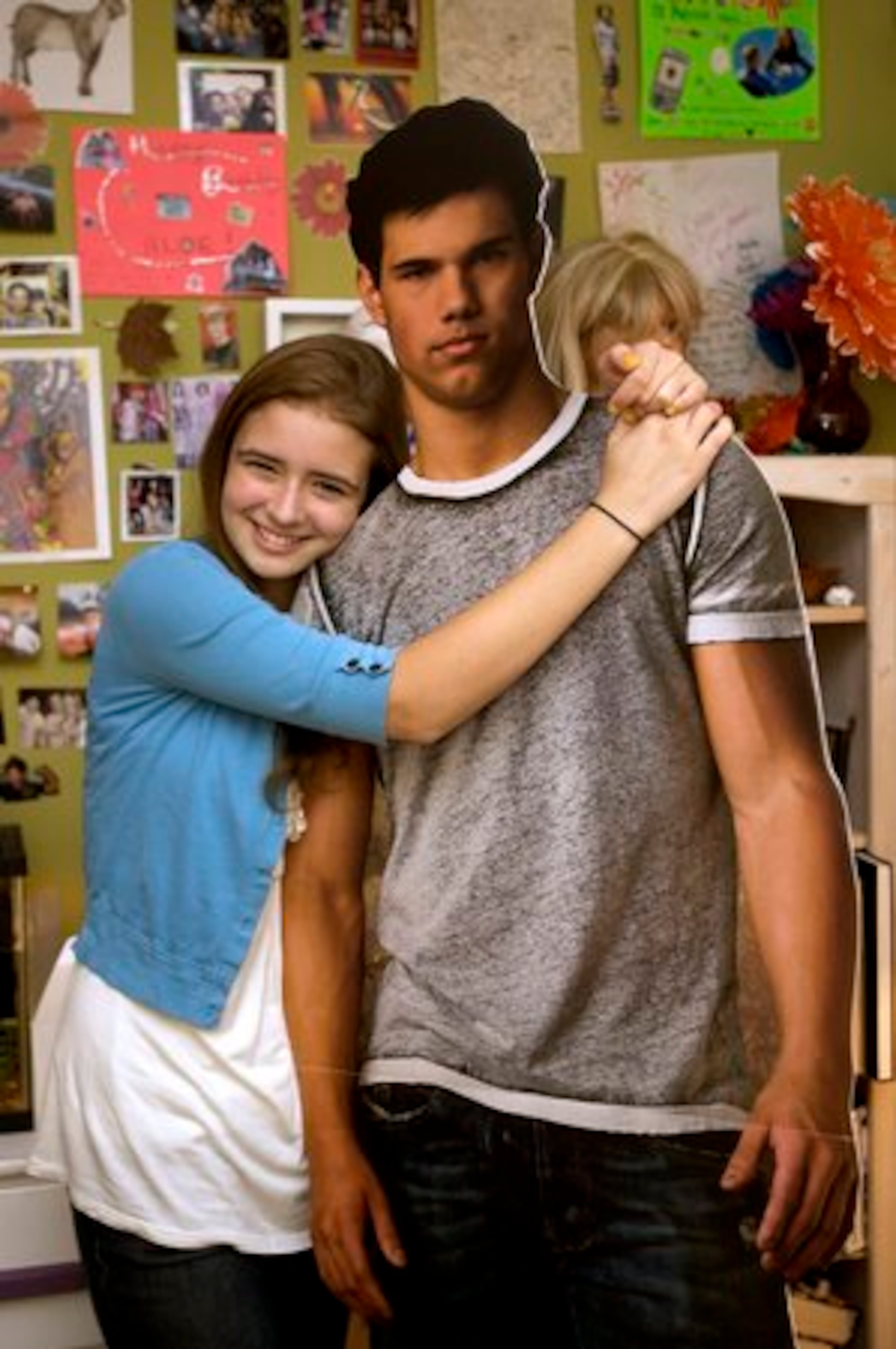 An adoring fan poses with her cutout of Taylor Lautner.
