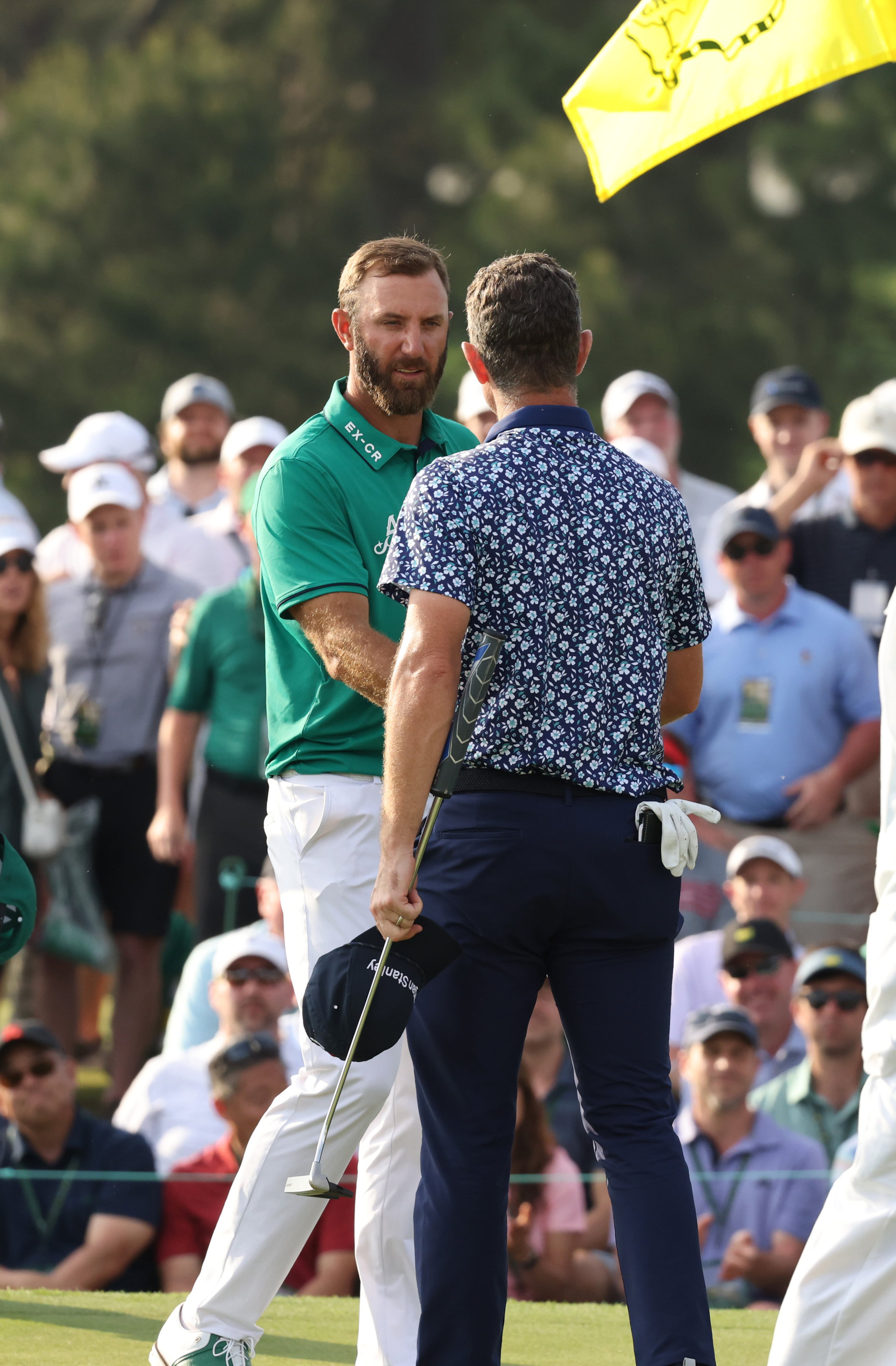 Dustin Johnson, green shirt, greets Justin Rose on the 18th hole during first round of the 2023 Masters Tournament at Augusta National Golf Club, Thursday, April 6, 2023, in Augusta, Ga. (Jason Getz / Jason.Getz@ajc.com)