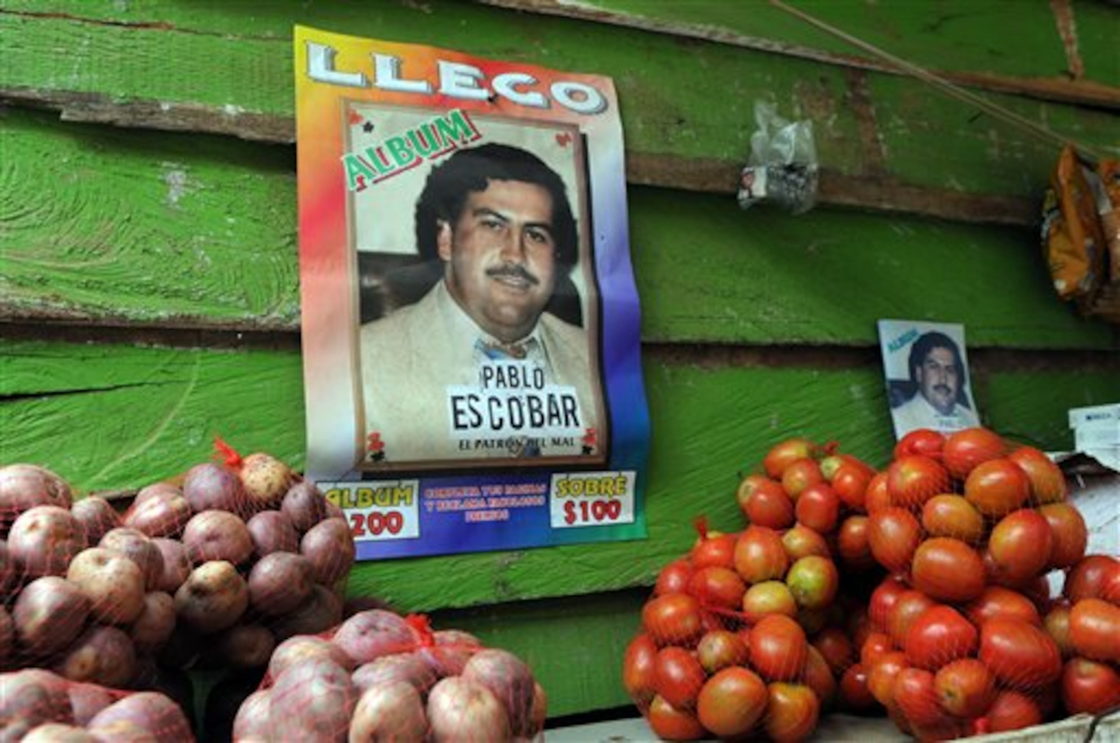 A poster promoting a magazine style publication about the life of the late Colombian drug trafficker Pablo Escobar hangs on the wall of small food store in the neighborhood Comuna Nororiental 1 in Medellin, Colombia, Wednesday, Aug. 8, 2012. (AP Photo/Luis Benavides)