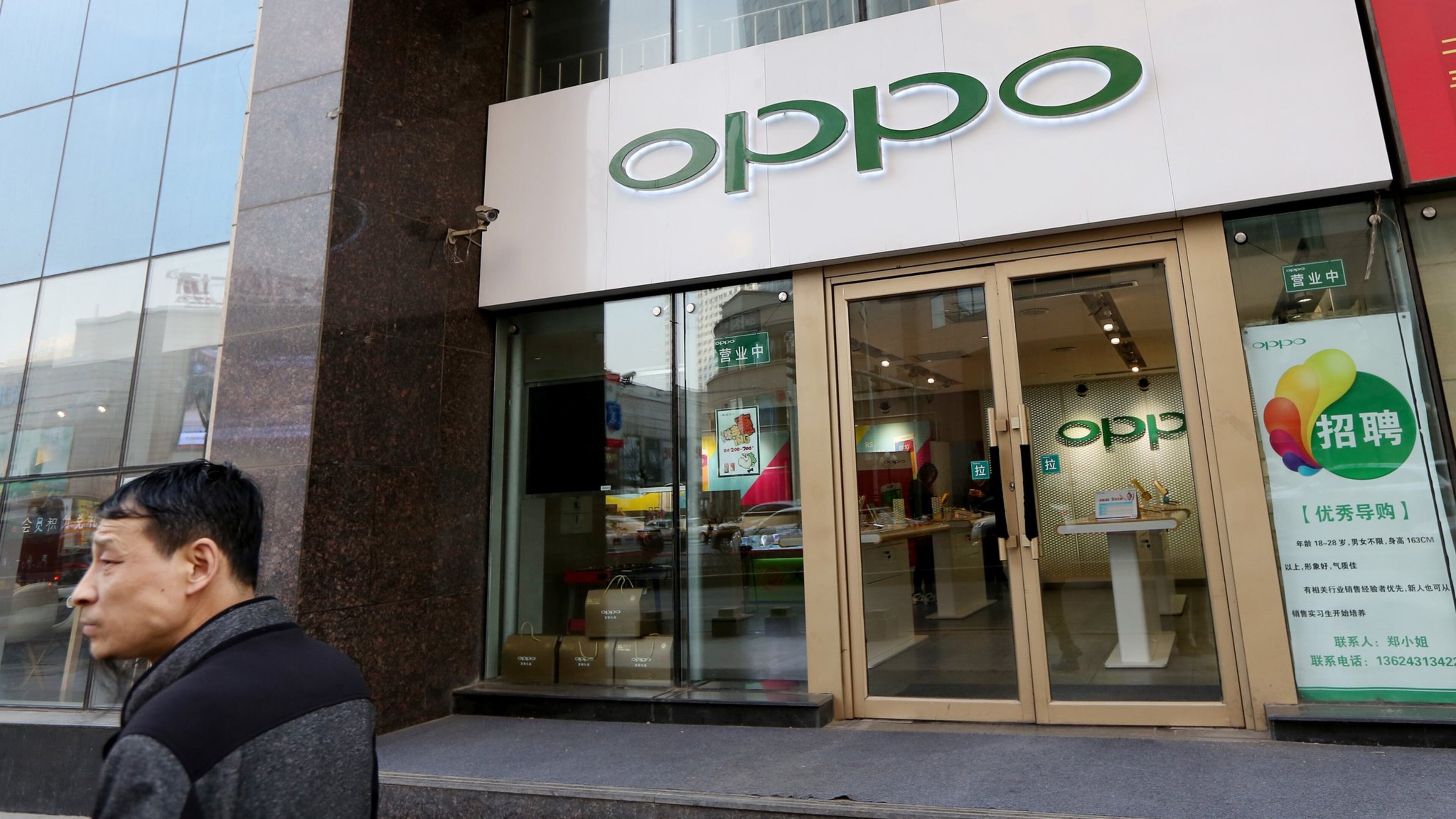 A pedestrian walks past a store of Oppo in Changchun city, northeast China’s Jilin province. (Imaginechina/Zuma Press/TNS)