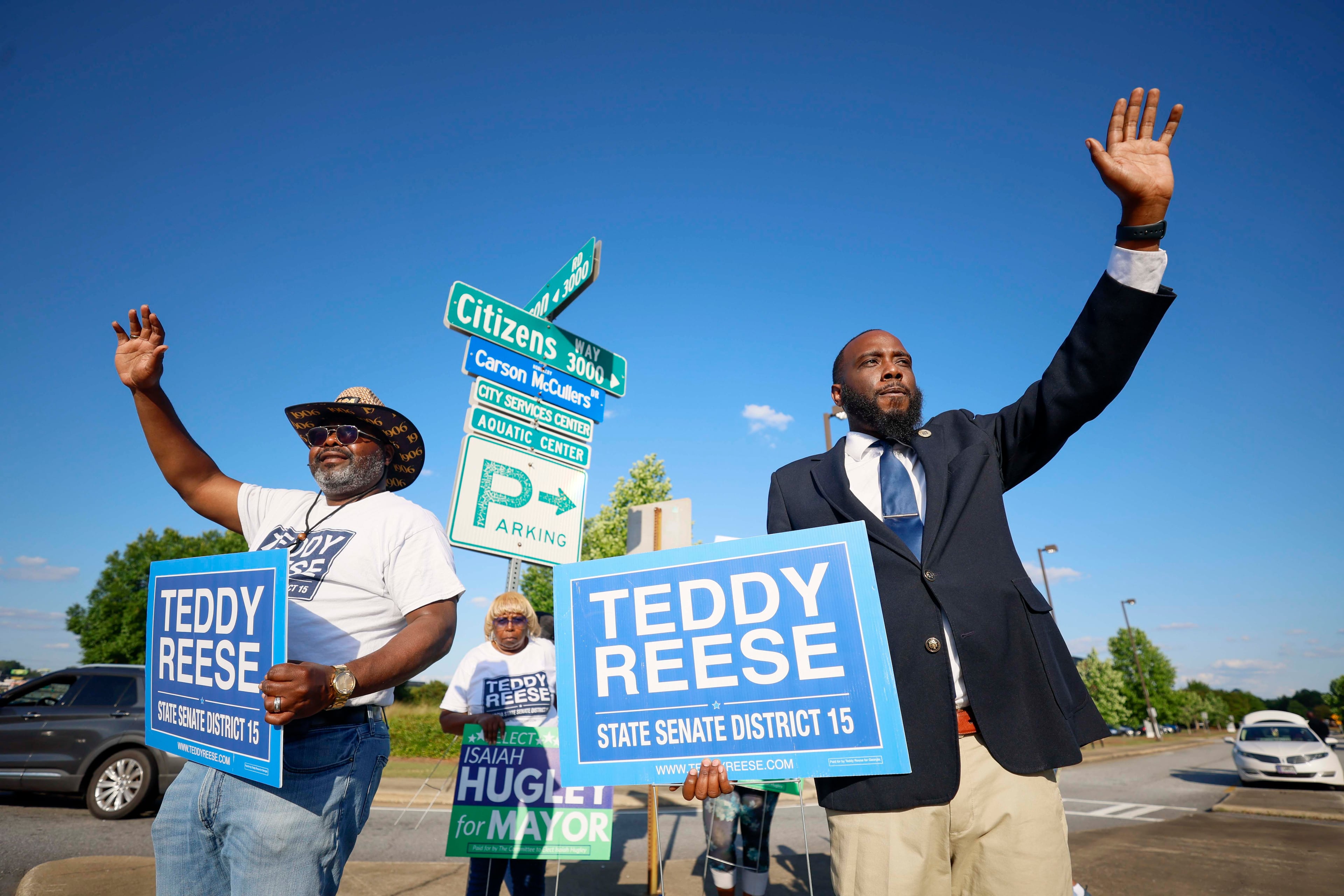 Marquese Averett, right, who is running for Georgia House District 140, campaigns for state Senate candidate Teddy Reese, left, on a busy Macon Rd and Citizens Way in Columbus, GA, on Wednesday, May 13, 2026. Averett, who is running unopposed, expresses his support for other candidates like Teddy Reese, who is running for the District 15 state Senate seat. (Miguel Martinez/AJC)
