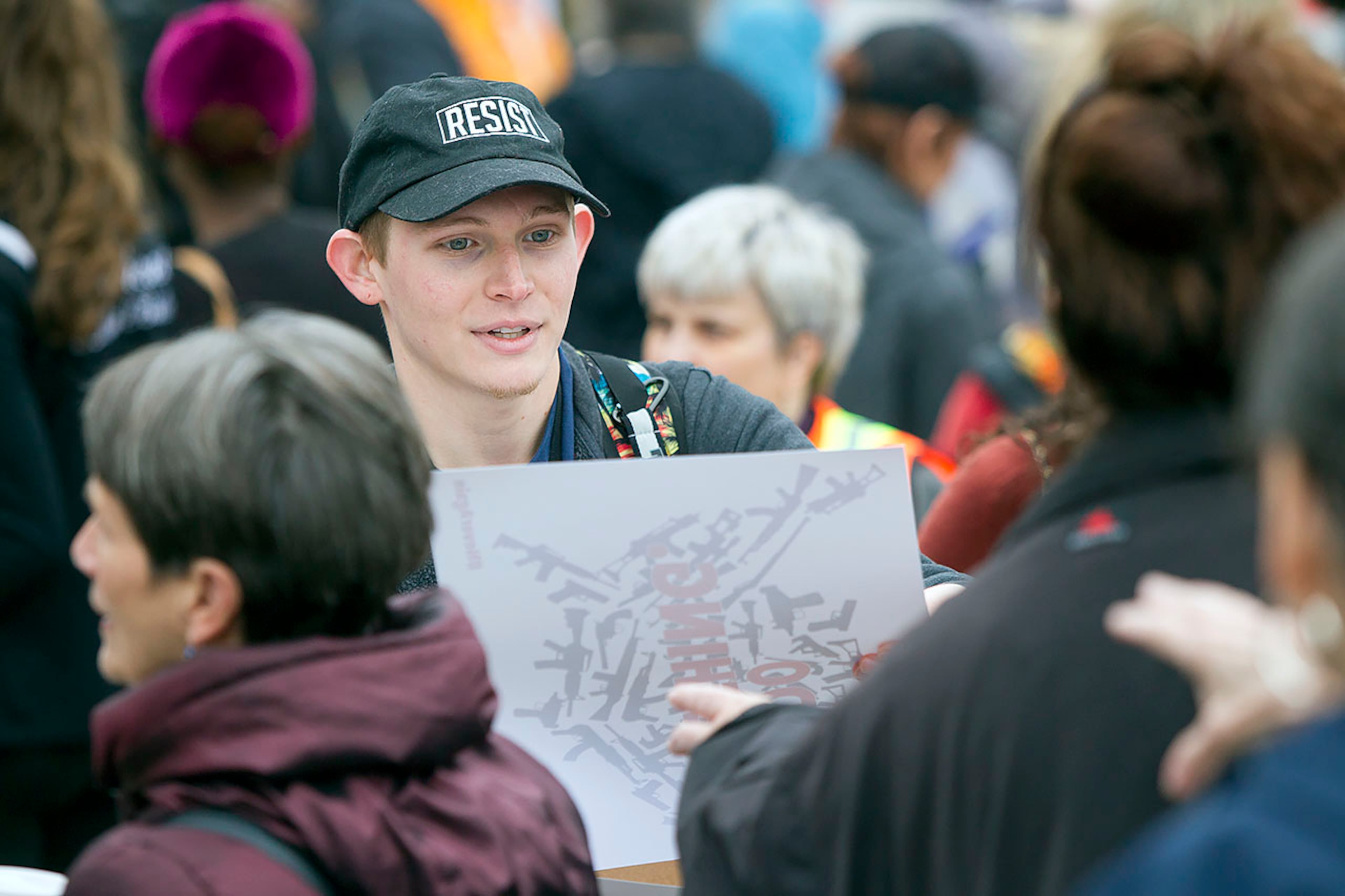 Tyler Boozer, a volunteer for March of our Lives, passes out posters during the March for our Lives event in Atlanta, Georgia, on Saturday, March 24, 2018. Boozer helped with the graphic design of posters and logos for the march. (REANN HUBER/REANN.HUBER@AJC.COM)