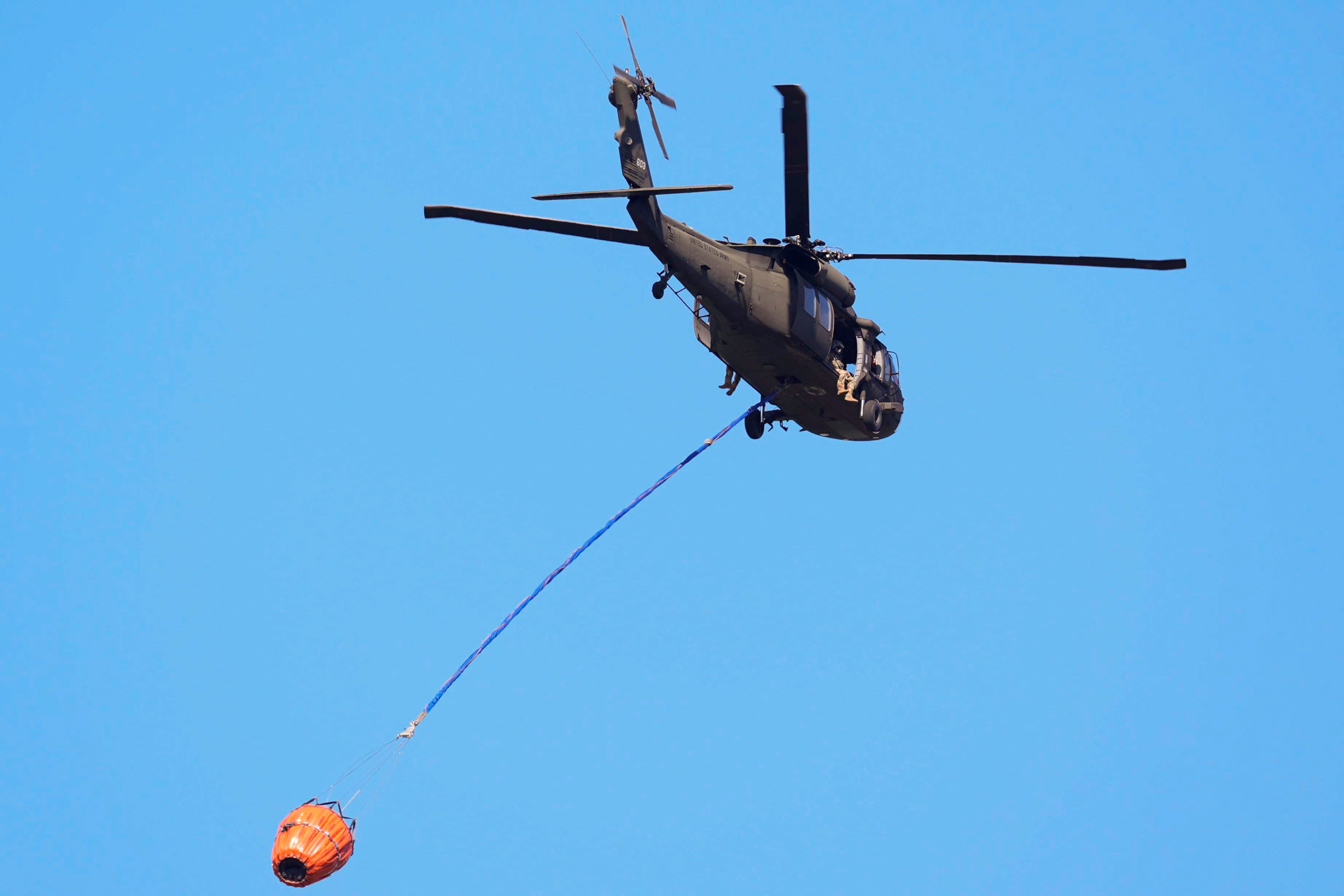 A helicopter carries water to the Brantley Highway 82 fire on Thursday, April 23, 2026, near Nahunta. (Mike Stewart/AP)