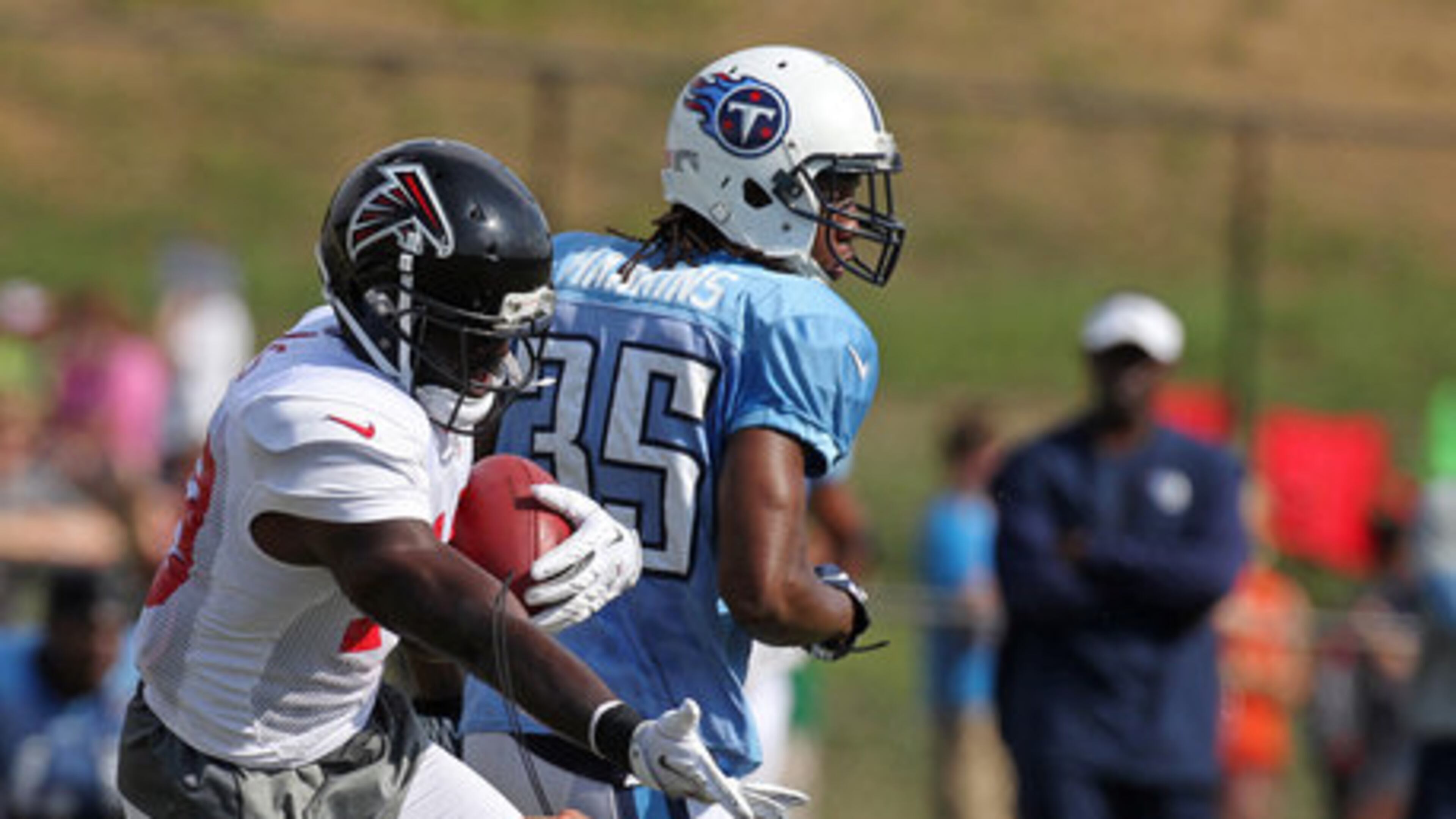 Atlanta Falcons wide receiver Drew Davis, left, reaches out after colliding with head coach Mike Smith following a catch against Tennessee Titans cornerback Chris Hawkins (35) during a joint NFL football practice in Dalton, 2012. (AJC)