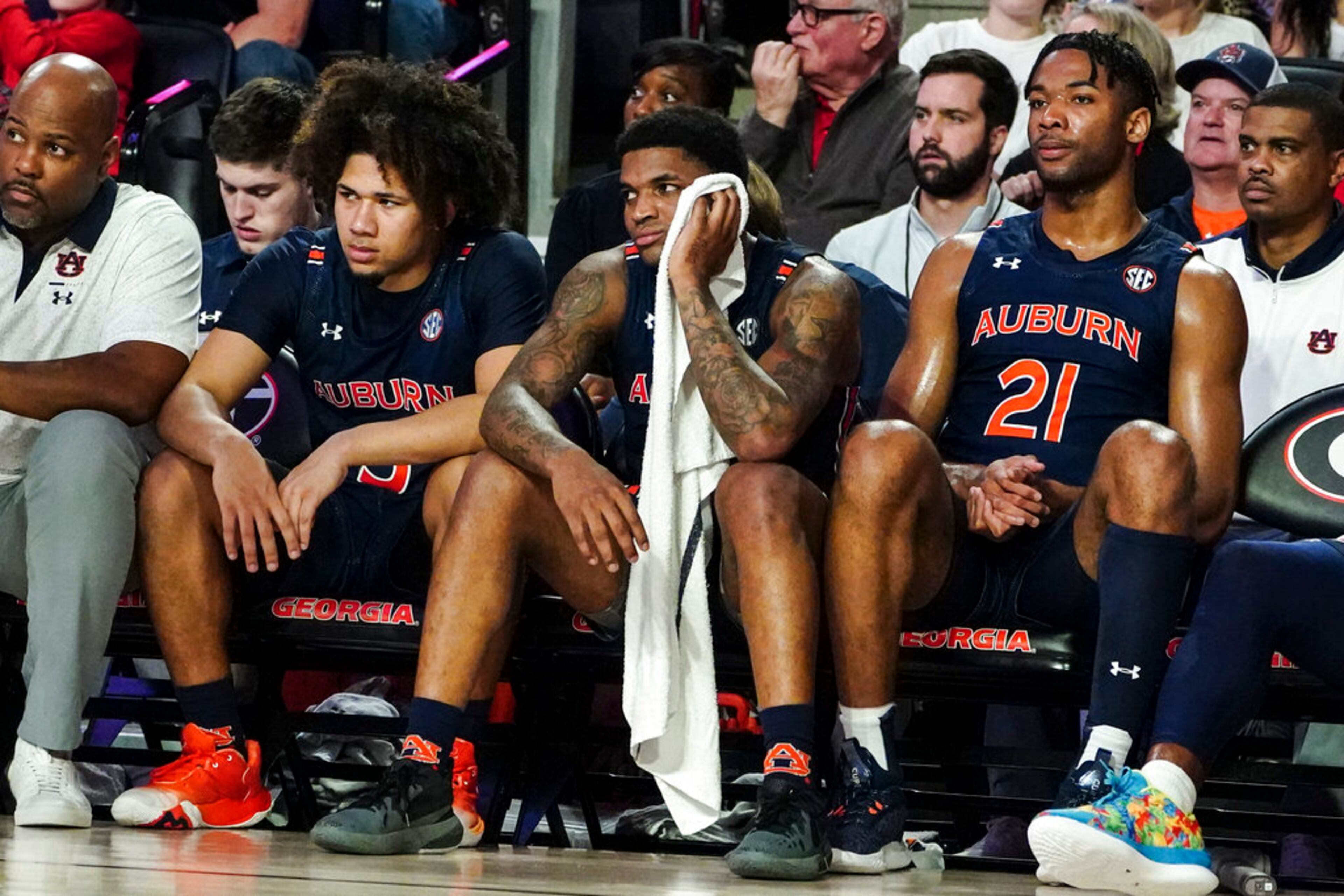 Auburn players from left; guard Tre Donaldson (3), guard K.D. Johnson (0) and forward Yohan Traore (21) sit on the bench during the second half of their loss to Georgia in an NCAA college basketball game Wednesday, Jan. 4, 2023, in Athens, Ga. (AP Photo/John Bazemore)