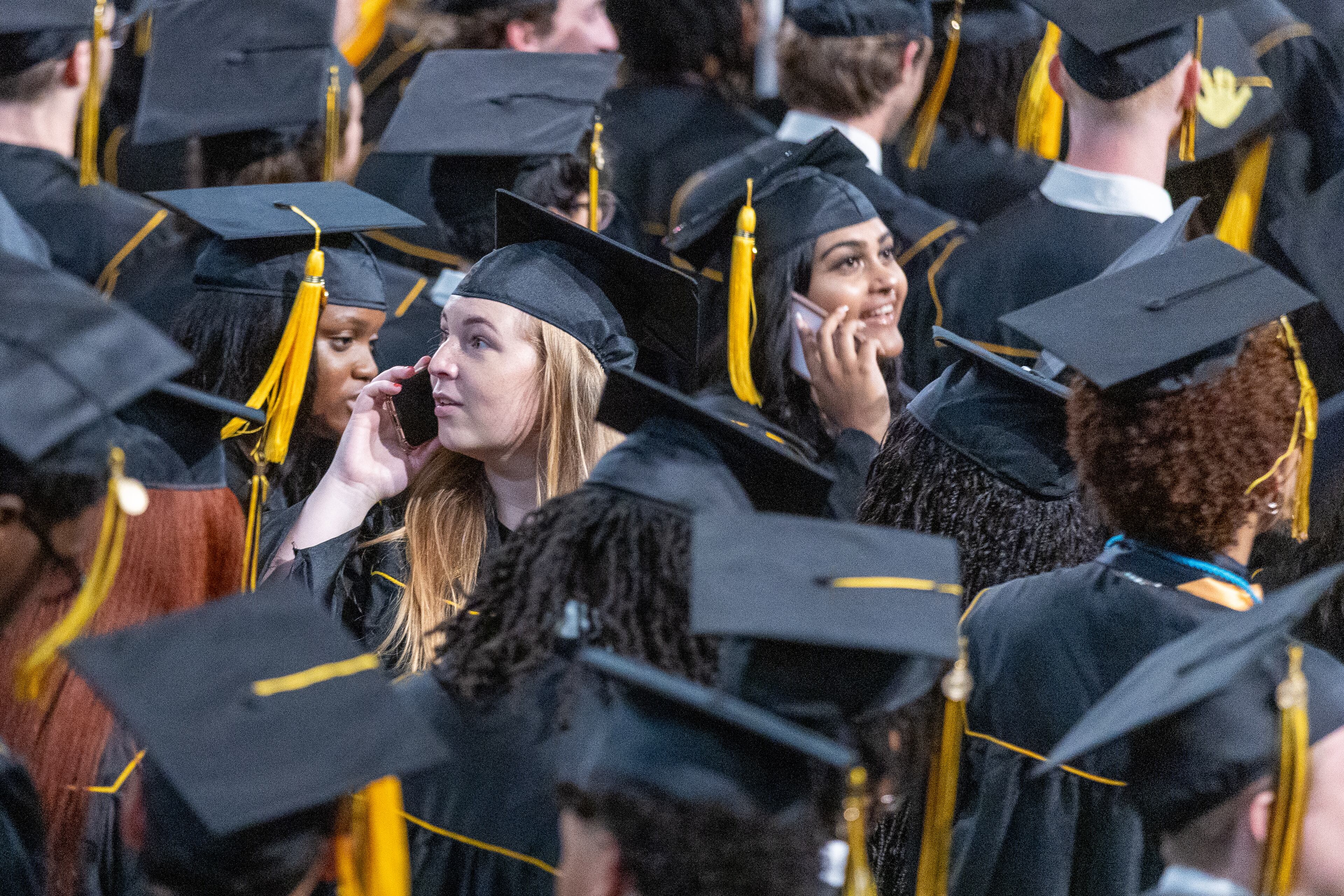 Graduates talk to their friends and family in the audience before the start of their graduation at Kennesaw State University on Tuesday, May 7, 2014. (Steve Schaefer / AJC)