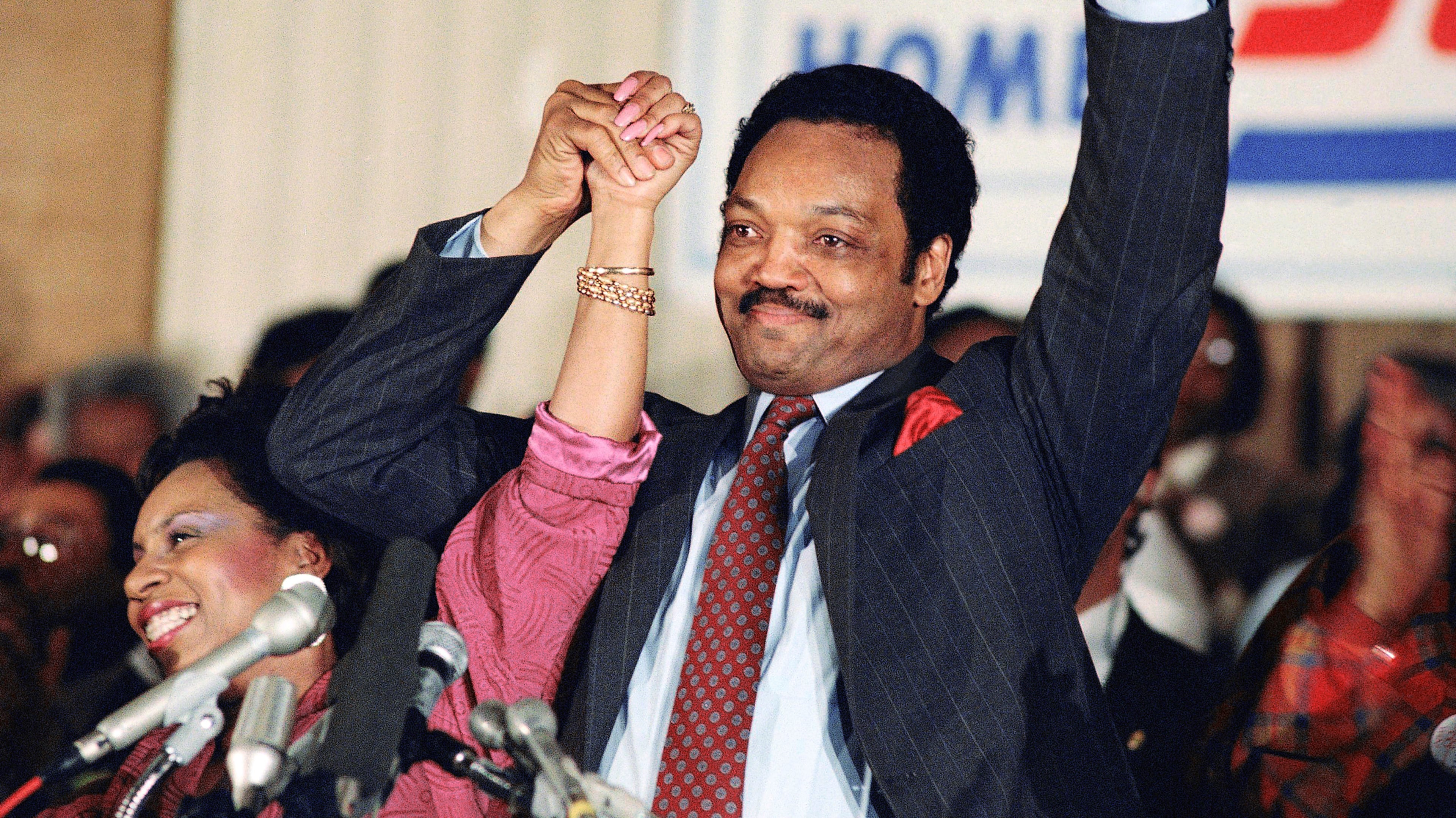 FILE - Democratic presidential hopeful Jesse Jackson with his wife, Jacqueline, salutes the cheering crowd at Operation Push in Chicago, March 10, 1988. (AP Photo/Fred Jewell, File)