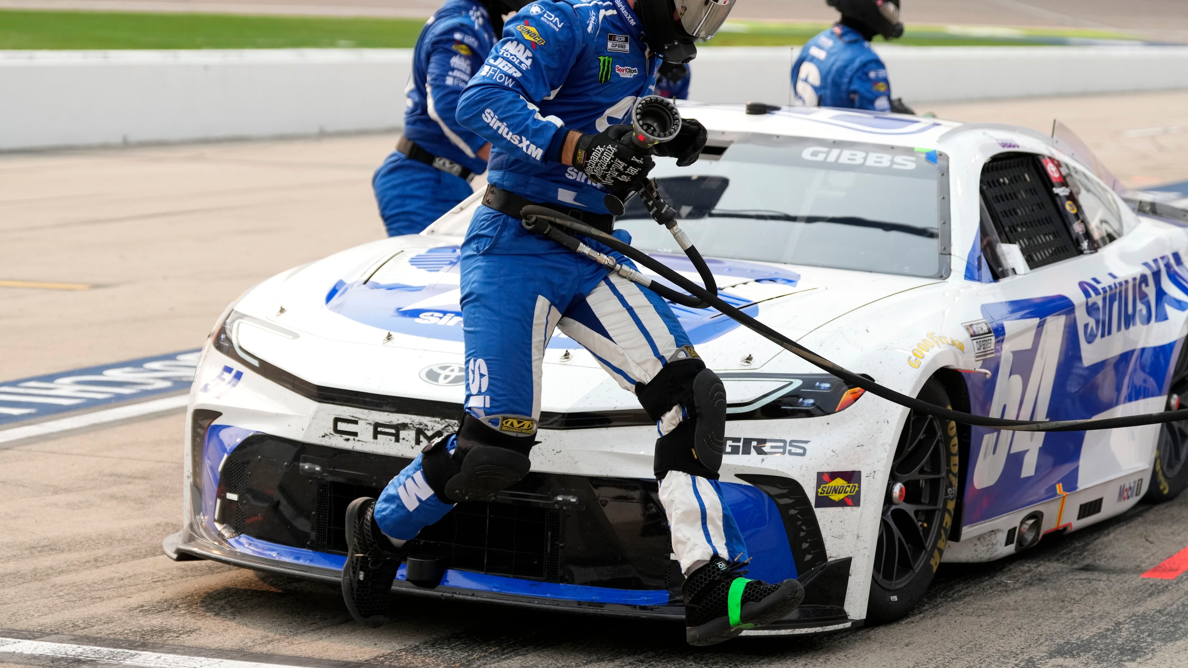 A crew member leaps in front of Ty Gibbs' car during a pit stop in a NASCAR Cup Series auto race, Sunday, Aug. 9, 2026, at Iowa Speedway in Newton, Iowa. (AP Photo/Charlie Neibergall)