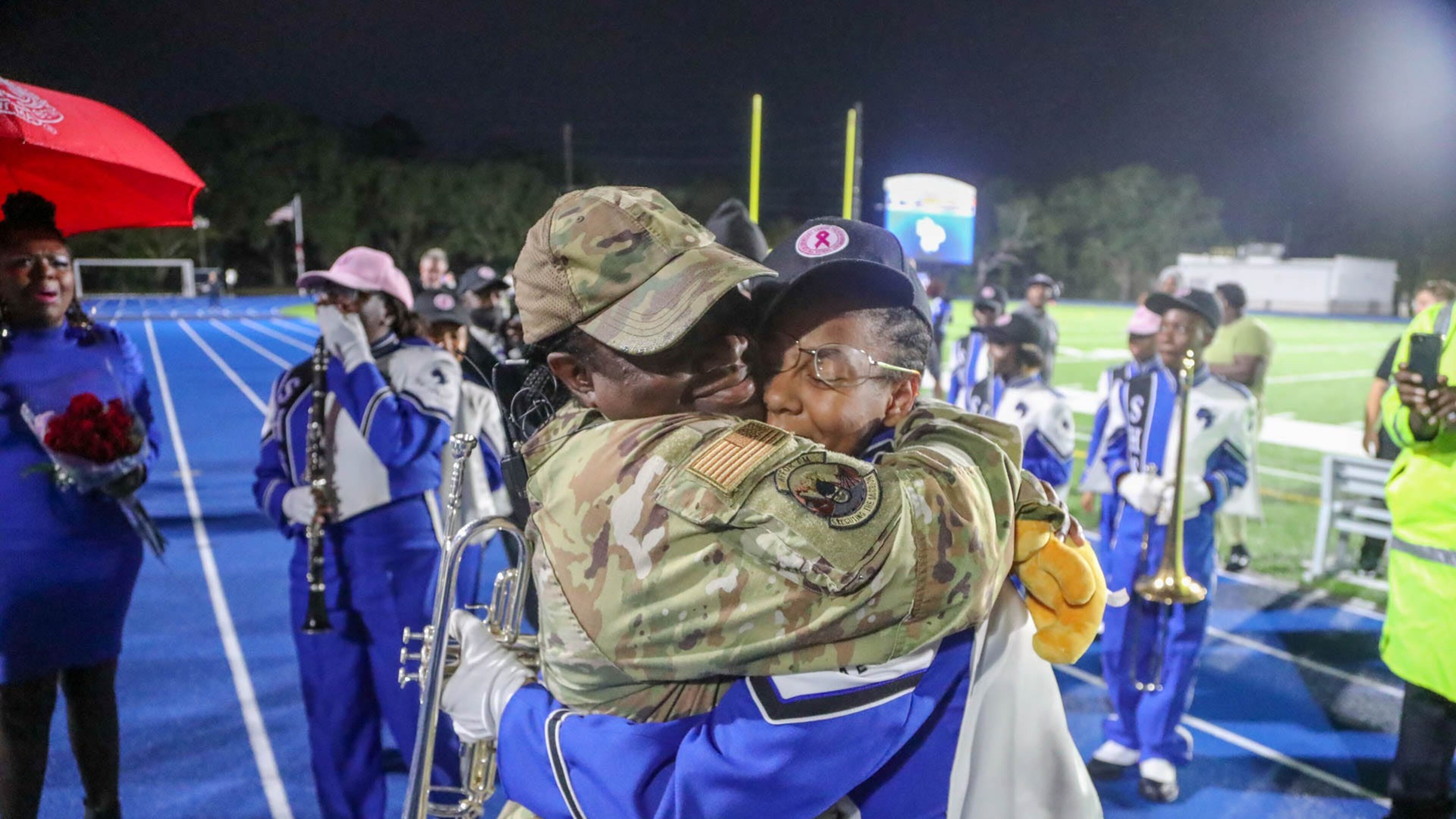 Chief Master Sergeant Alicia Stewart of the 165th Airlift Wing, embraces her daughter Alayna Duke after surprising her following the Savannah High School Marching Band halftime performance on Friday, October 13, 2023 at Savannah High Stadium.